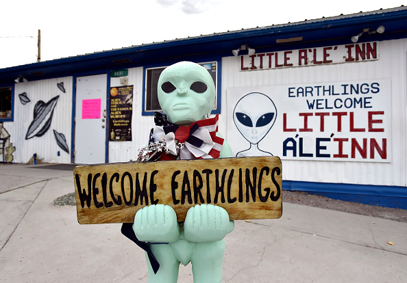 An alien-like statue displays a sign welcoming guests to the Little A'le' Inn restaurant and gift shop in Rachel, Nevada on July 22, 2019.