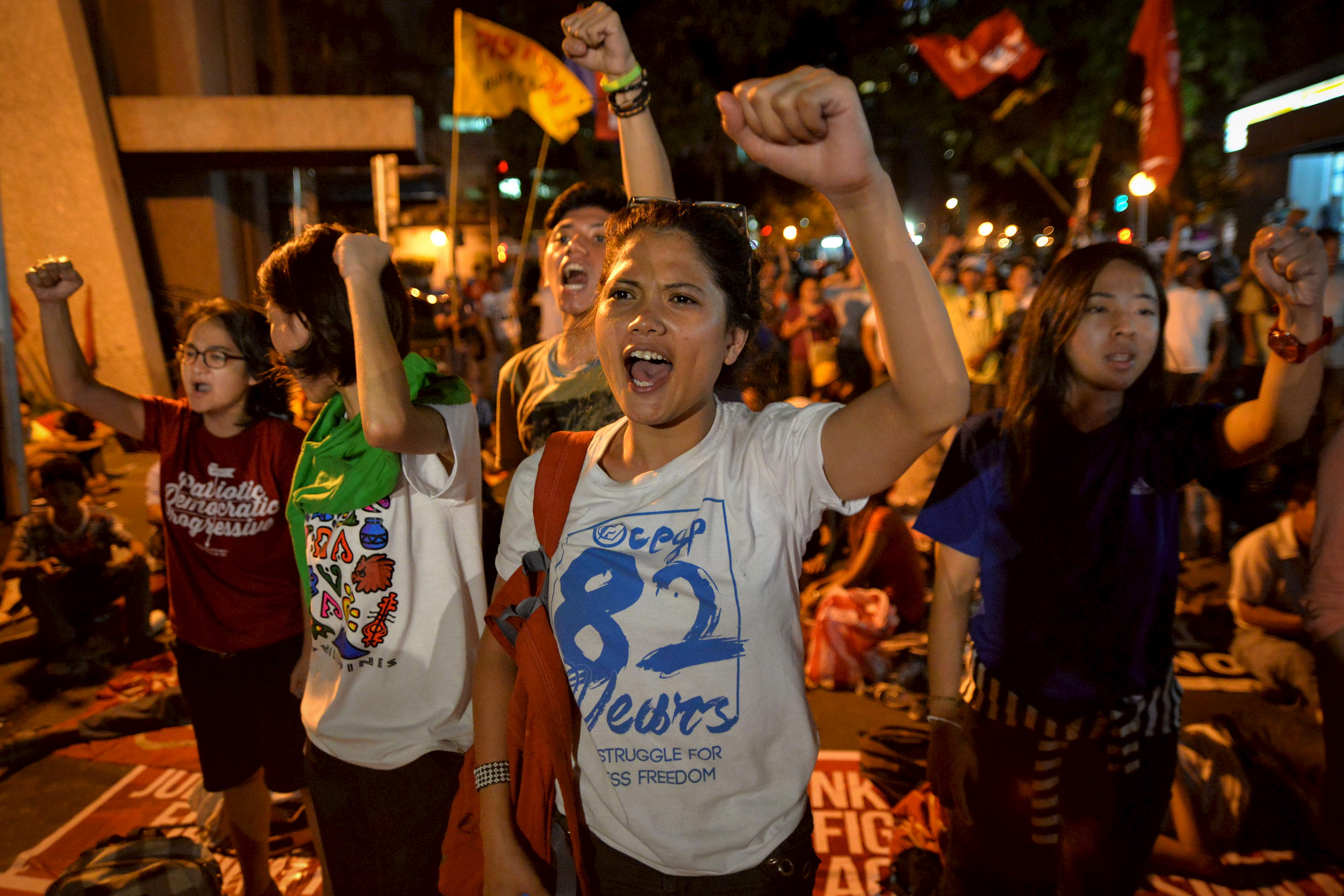 Activists clench their fists as they react after it was announced that the execution was delayed for death row prisoner Mary Jane Veloso, during a vigil outside Indonesian embassy in Makati