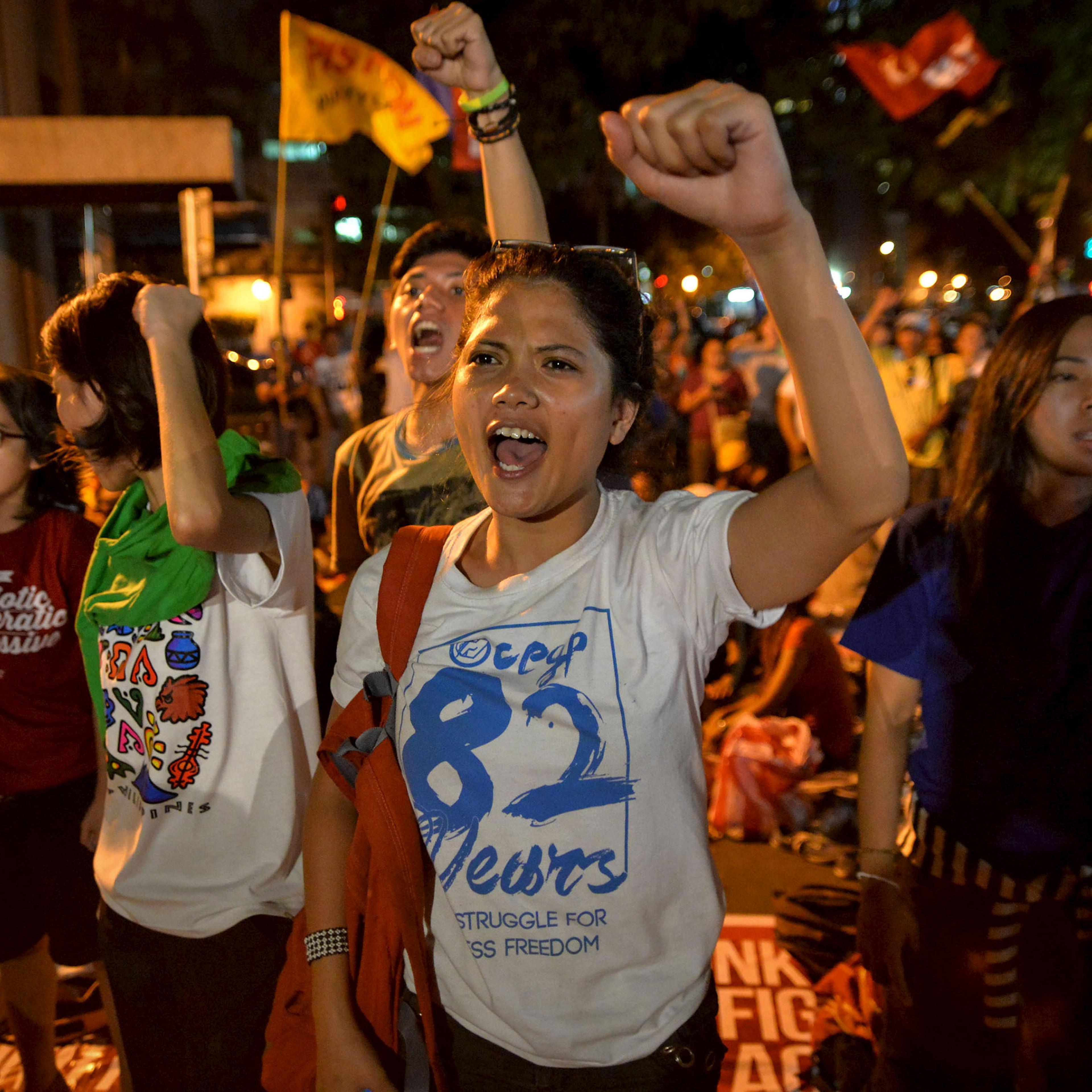 Activists clench their fists as they react after it was announced that the execution was delayed for death row prisoner Mary Jane Veloso, during a vigil outside Indonesian embassy in Makati