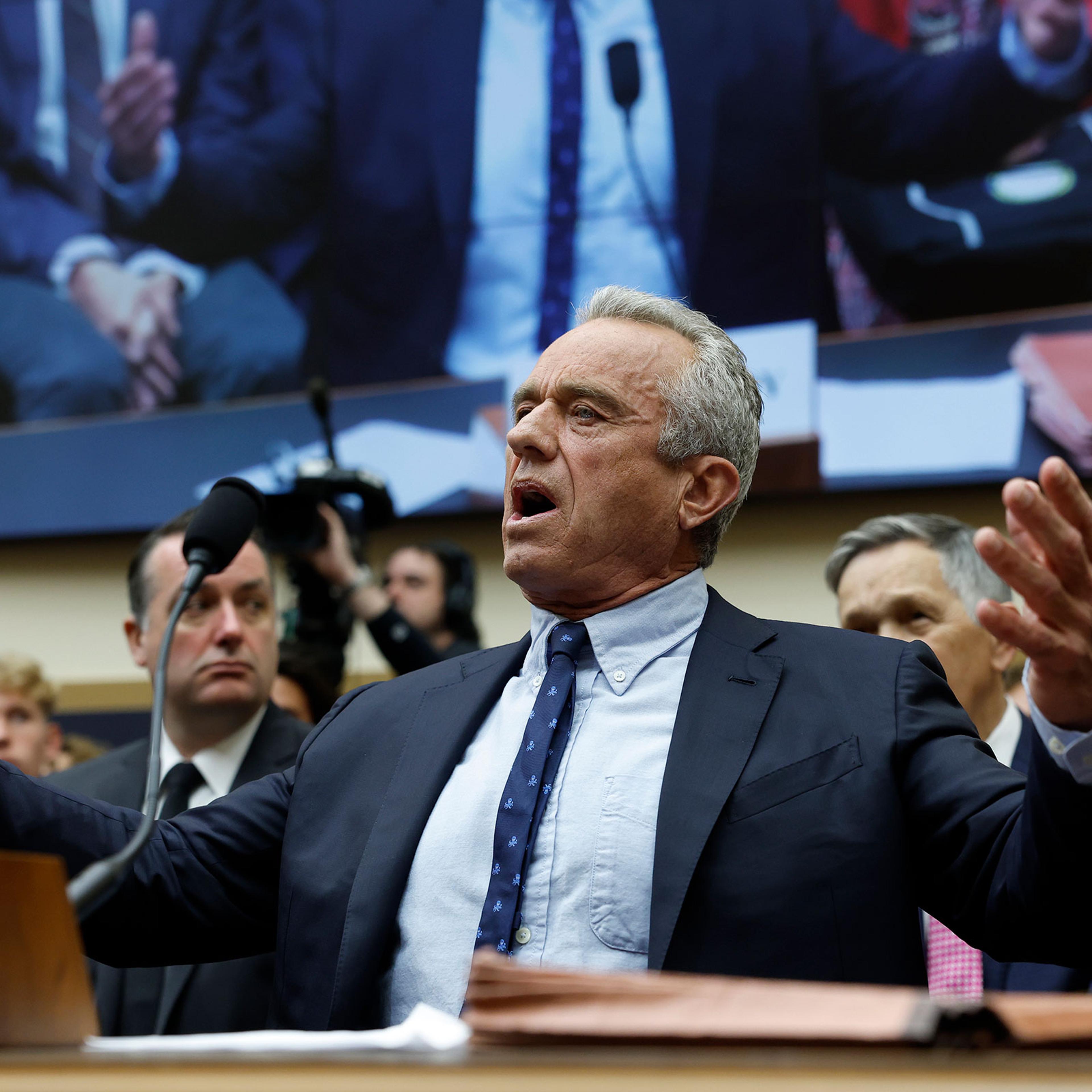 Robert F. Kennedy Jr. gestures his arms out as he speaks into a microphone during testimony at a House Judiciary Subcommittee meeting