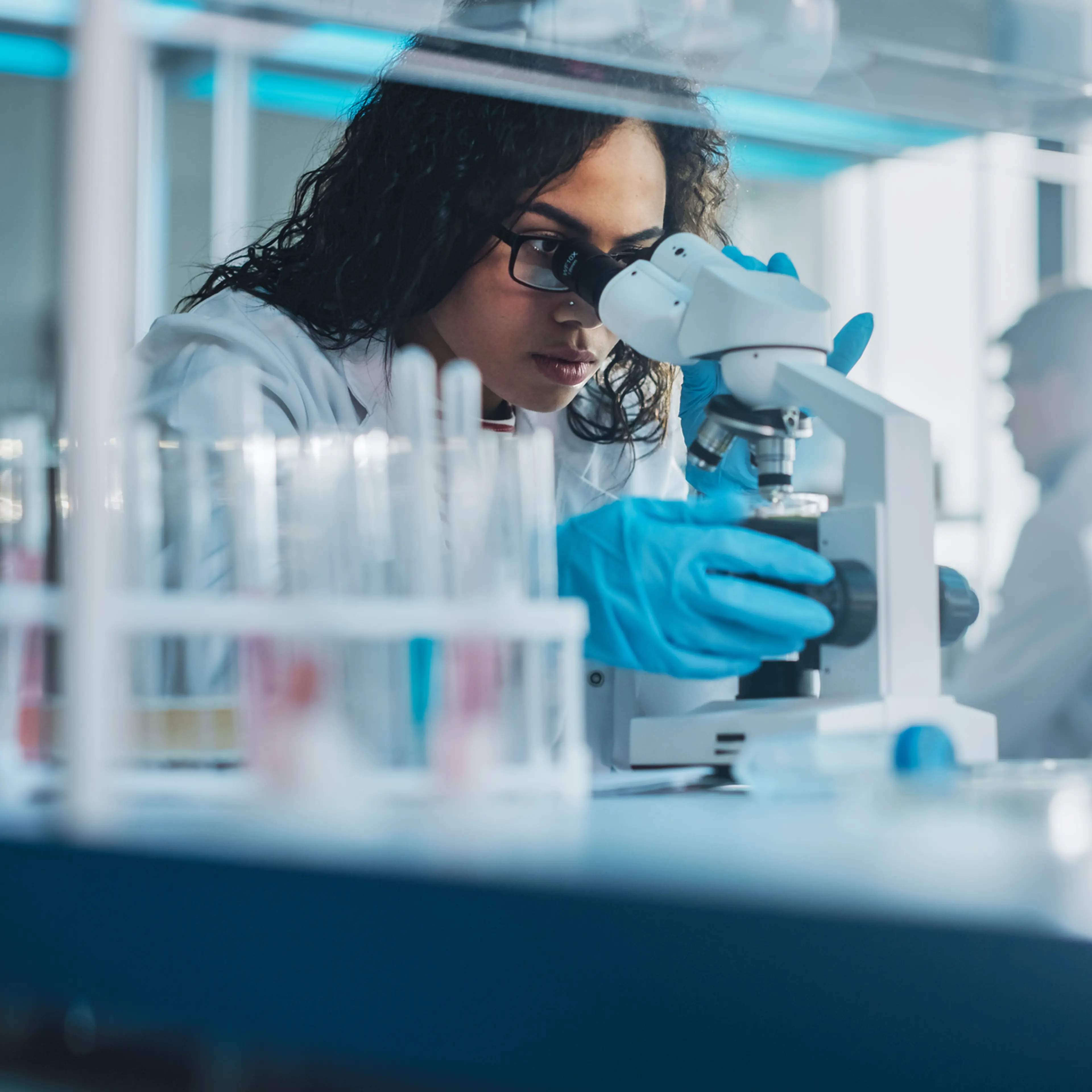 Medical Science Laboratory: Portrait of Beautiful Black Scientist Looking Under Microscope Does Analysis of Test Sample. Ambitious Young Biotechnology Specialist, working with Advanced Equipment
