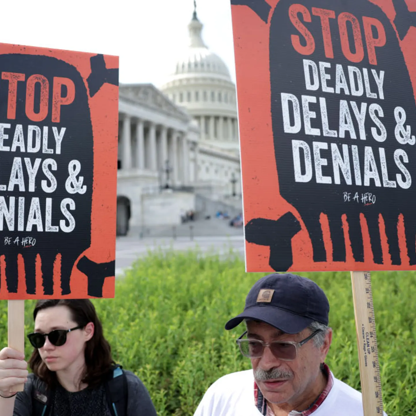 People holding signs protesting health insurance denials.