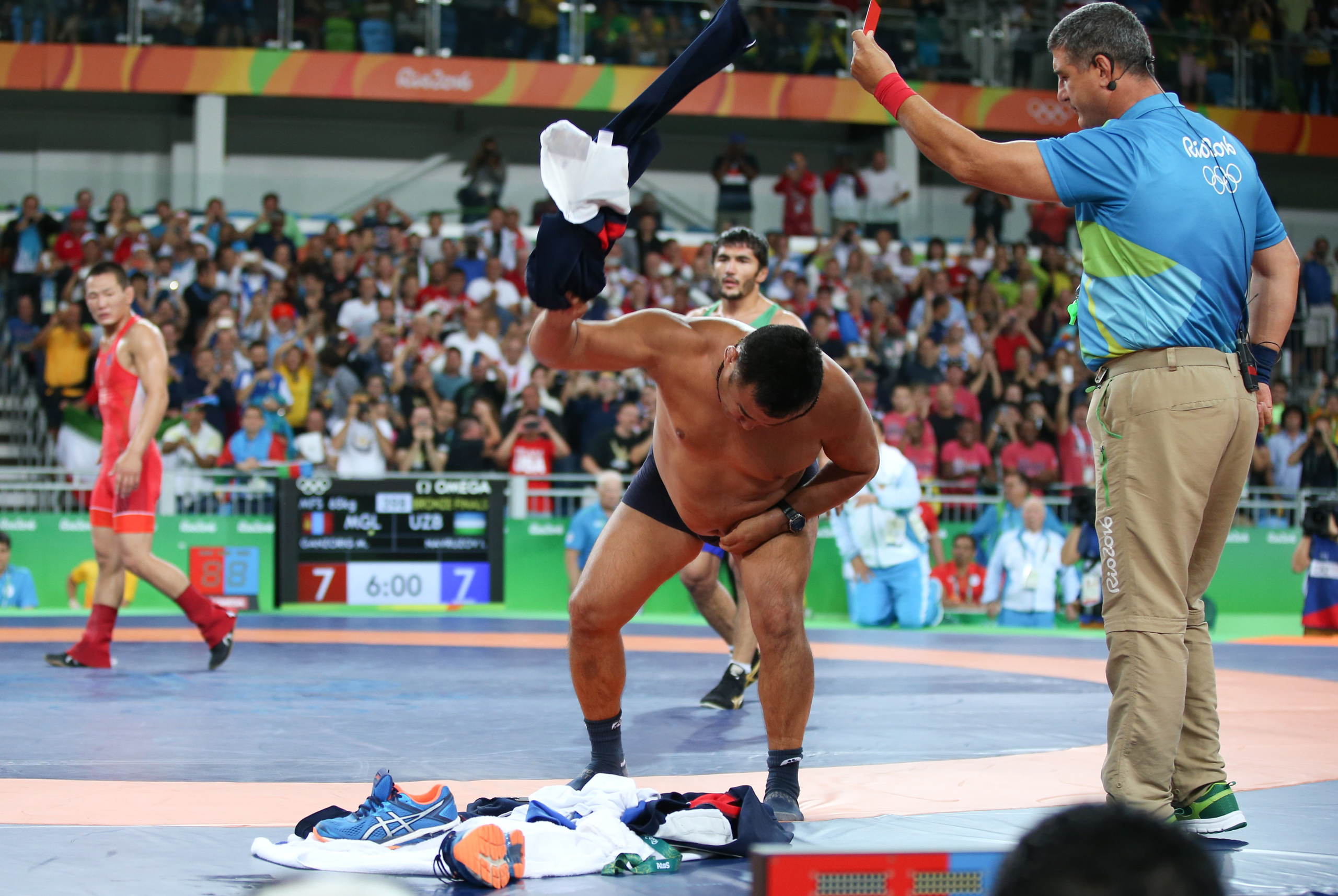 2016 Rio Olympics - Wrestling - Final - Men's Freestyle 65 kg Bronze - Carioca Arena 2 - Rio de Janeiro, Brazil - 21/08/2016. The coach of Mandakhnaran Ganzorig (MGL) of Mongolia takes off his clothes as he protests after the match against Ikhtiyor Navru