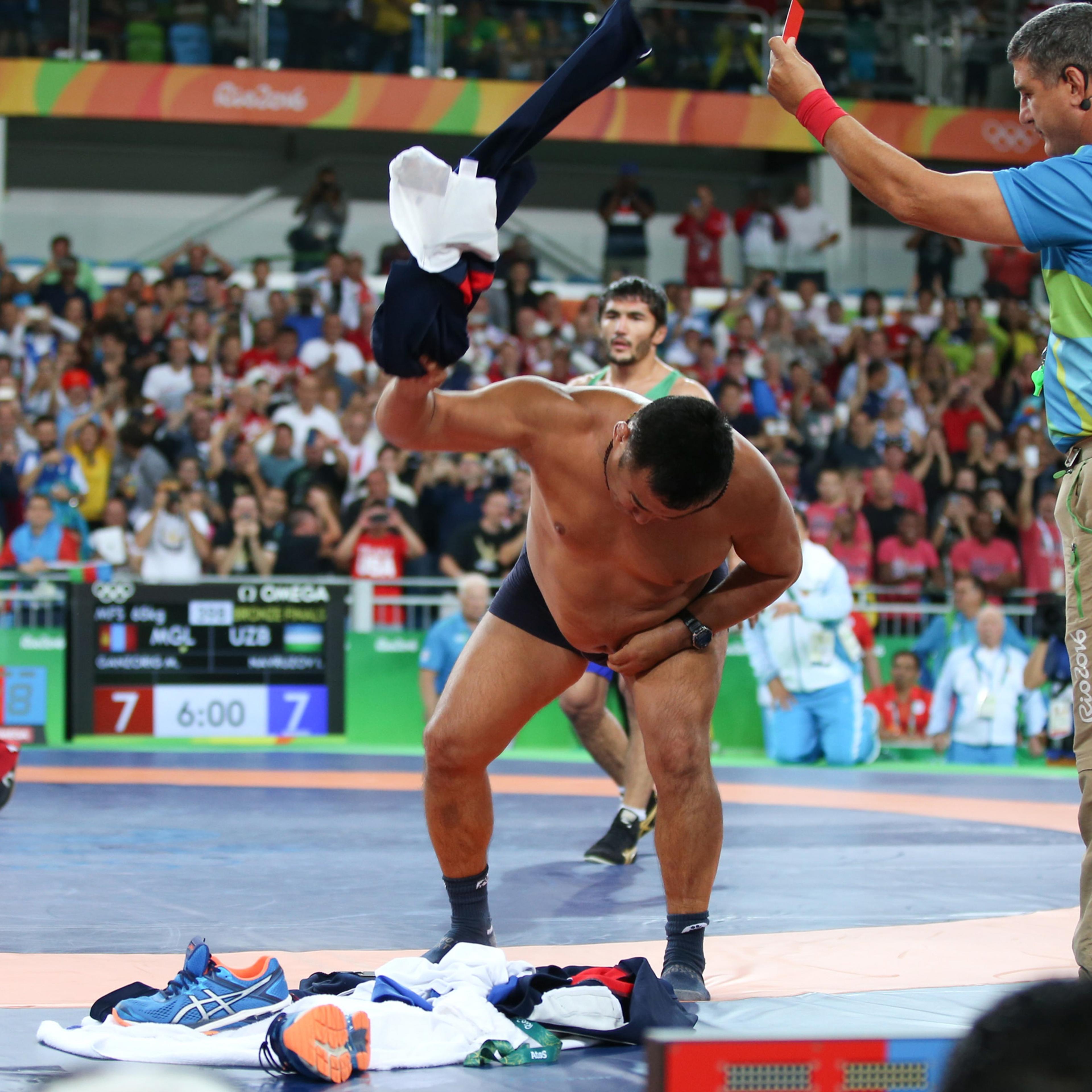 2016 Rio Olympics - Wrestling - Final - Men's Freestyle 65 kg Bronze - Carioca Arena 2 - Rio de Janeiro, Brazil - 21/08/2016. The coach of Mandakhnaran Ganzorig (MGL) of Mongolia takes off his clothes as he protests after the match against Ikhtiyor Navru