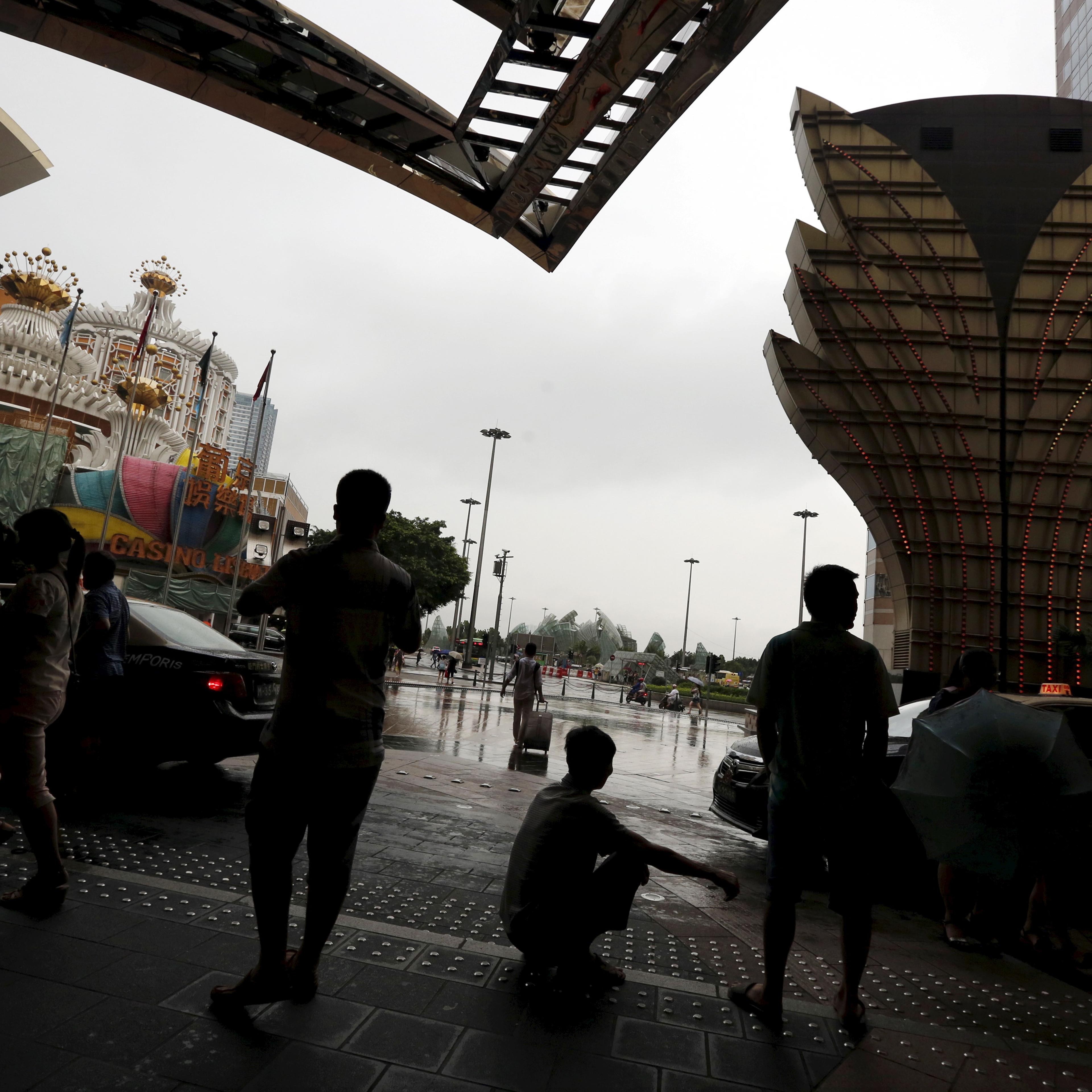 Visitors from mainland China wait outside a casino in Macau