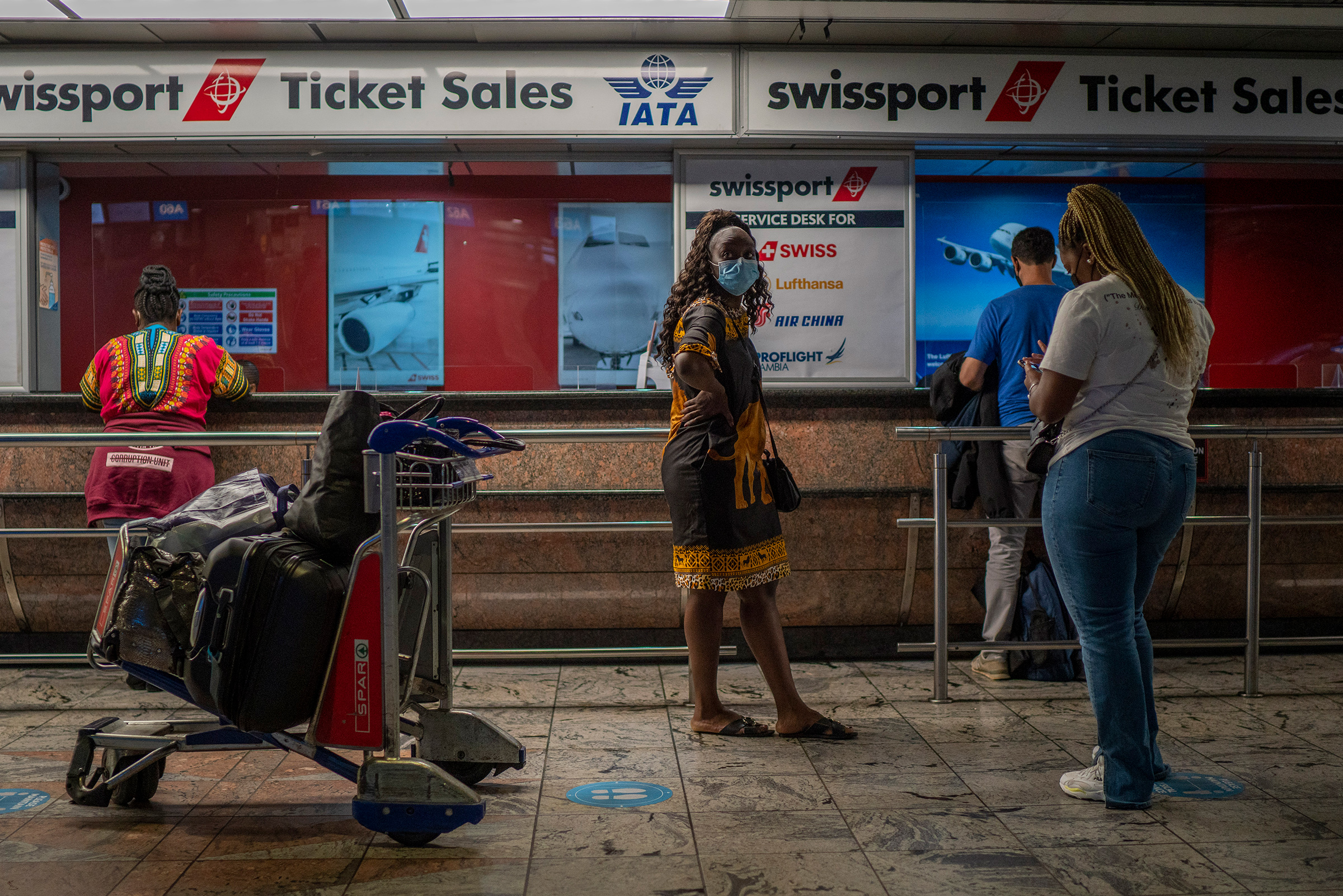 Passengers wait at a ticket counter at Johannesburg's O.R. Tambo's airport on Nov. 29. A pandemic-weary world faces weeks of confusing uncertainty as countries restrict travel and take other steps to halt the newest potentially risky coronavirus mutant b