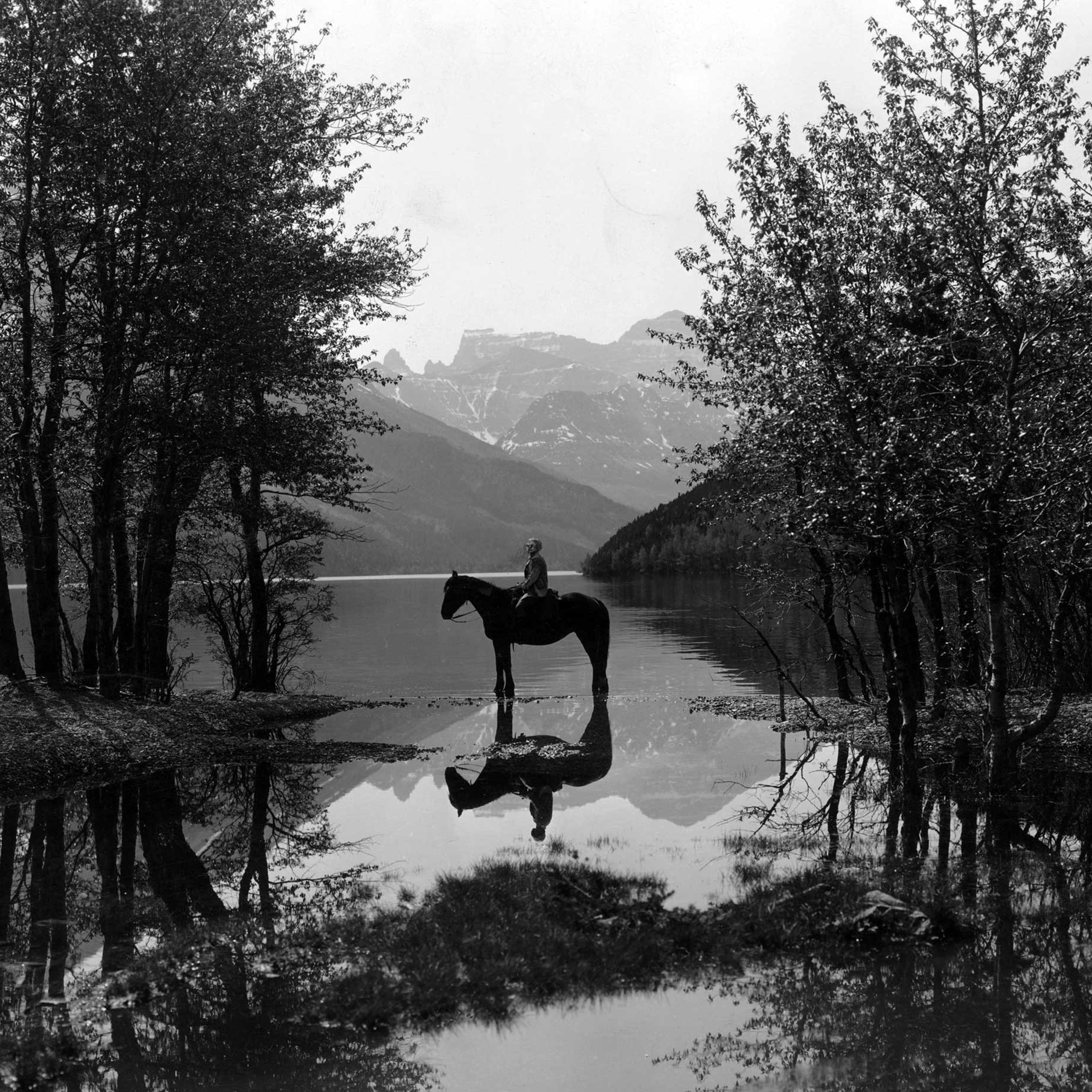 A rider on horseback in Waterton Lakes National Park, British Columbia. Circa 1930.