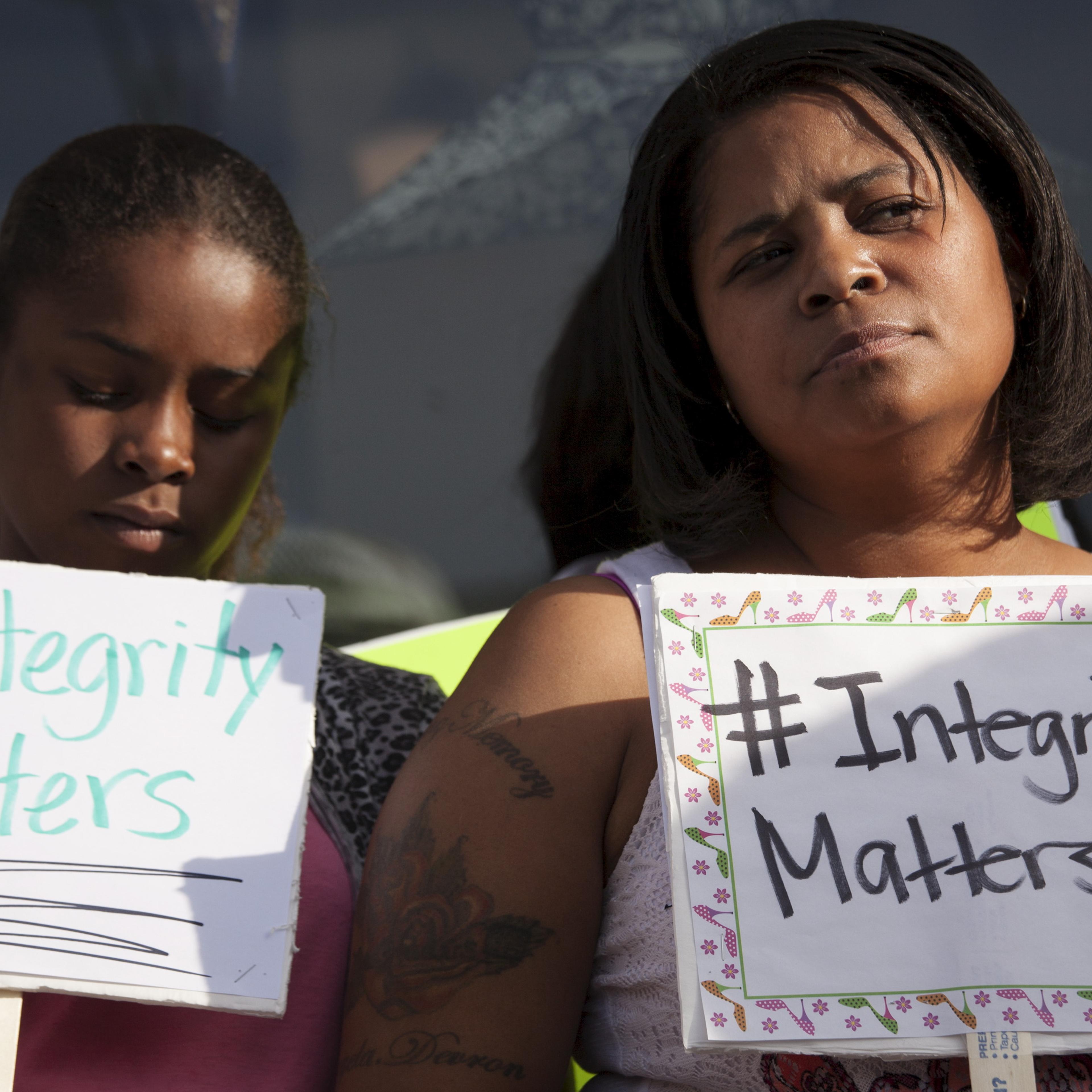 Women hold signs during a protest in front of the National Association for the Advancement of Colored People (NAACP) headquarters in Spokane, Washington