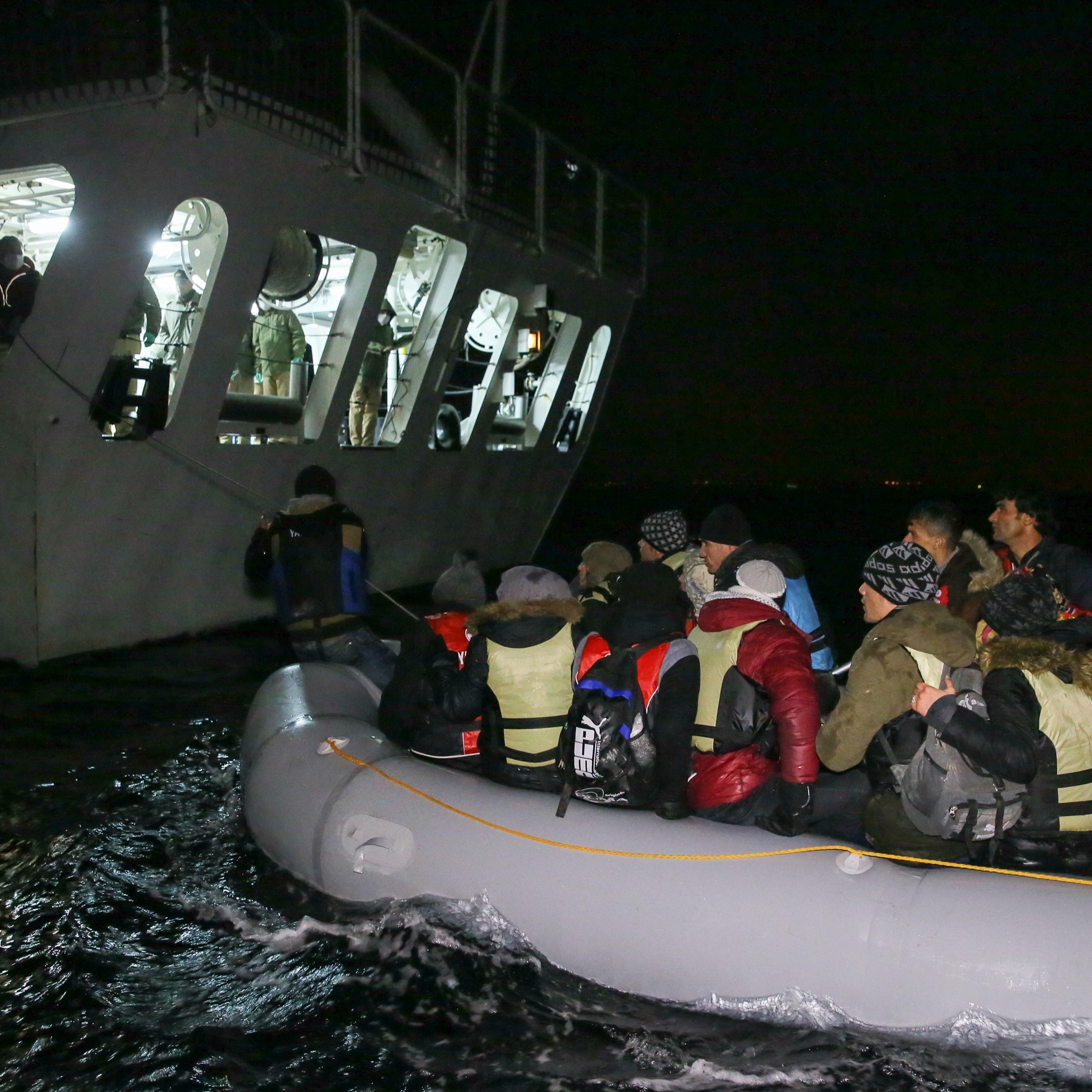 Turkish coast guards pull a refugee boat into a Turkish Coast Guard ship during a rescue operation for the asylum seeker refugees who were illegally trying to reach Greece through the Aegean Sea with a overloaded inflatable boat, on the shores of Turkey'