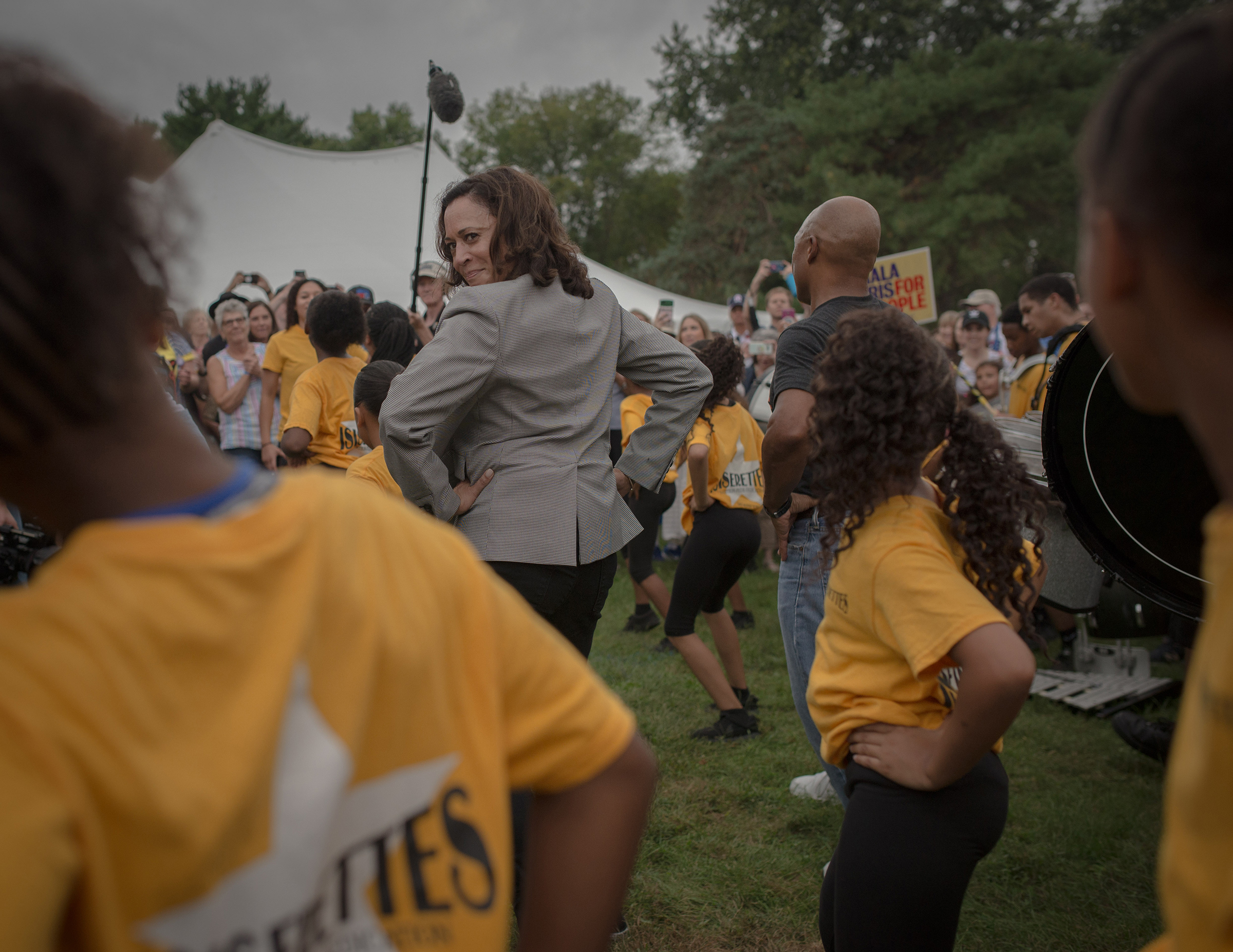 Kamala Harris takes a cue from a local drill team at the Des Moines Steakfry during her campaign for presidency on Sept. 21