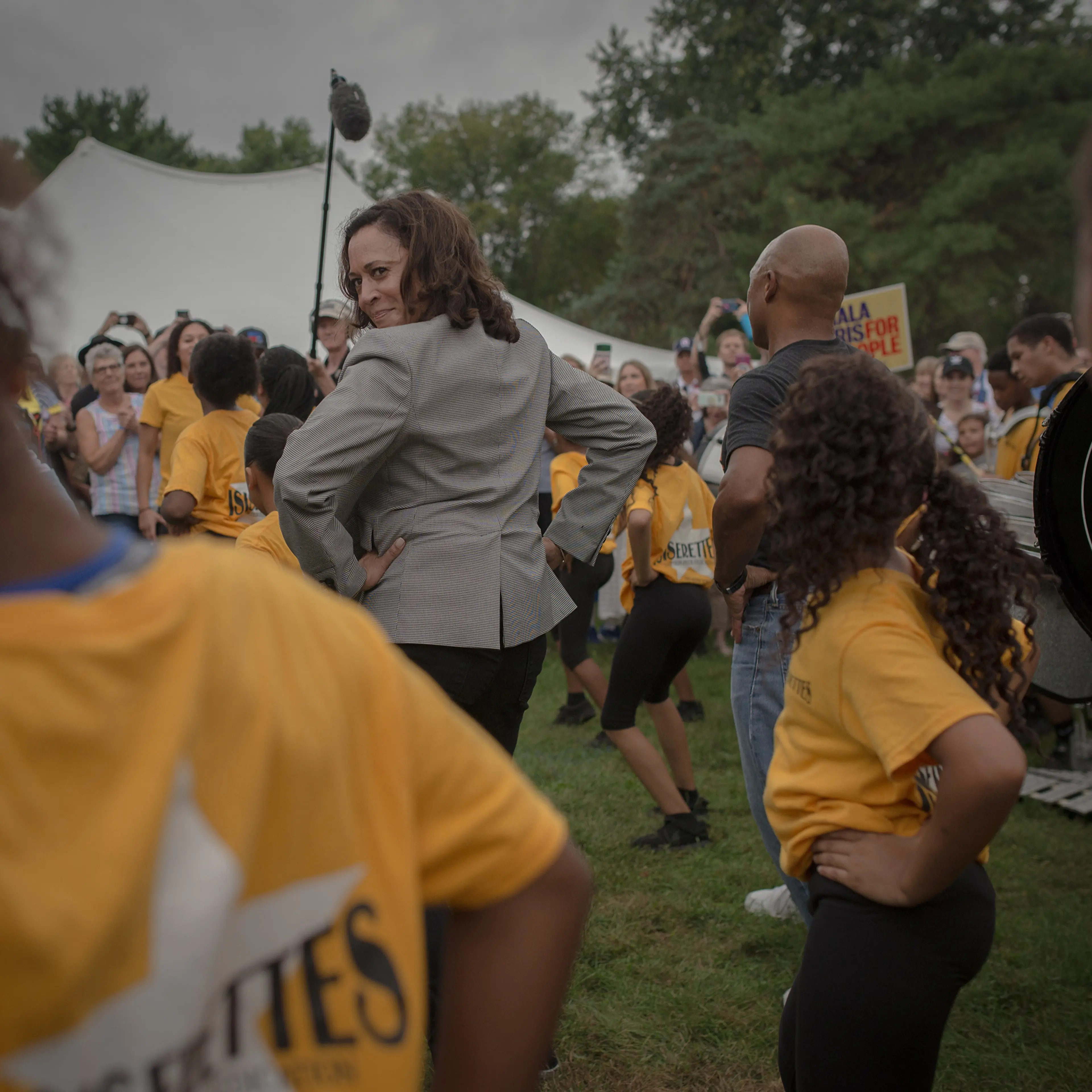 Kamala Harris takes a cue from a local drill team at the Des Moines Steakfry during her campaign for presidency on Sept. 21