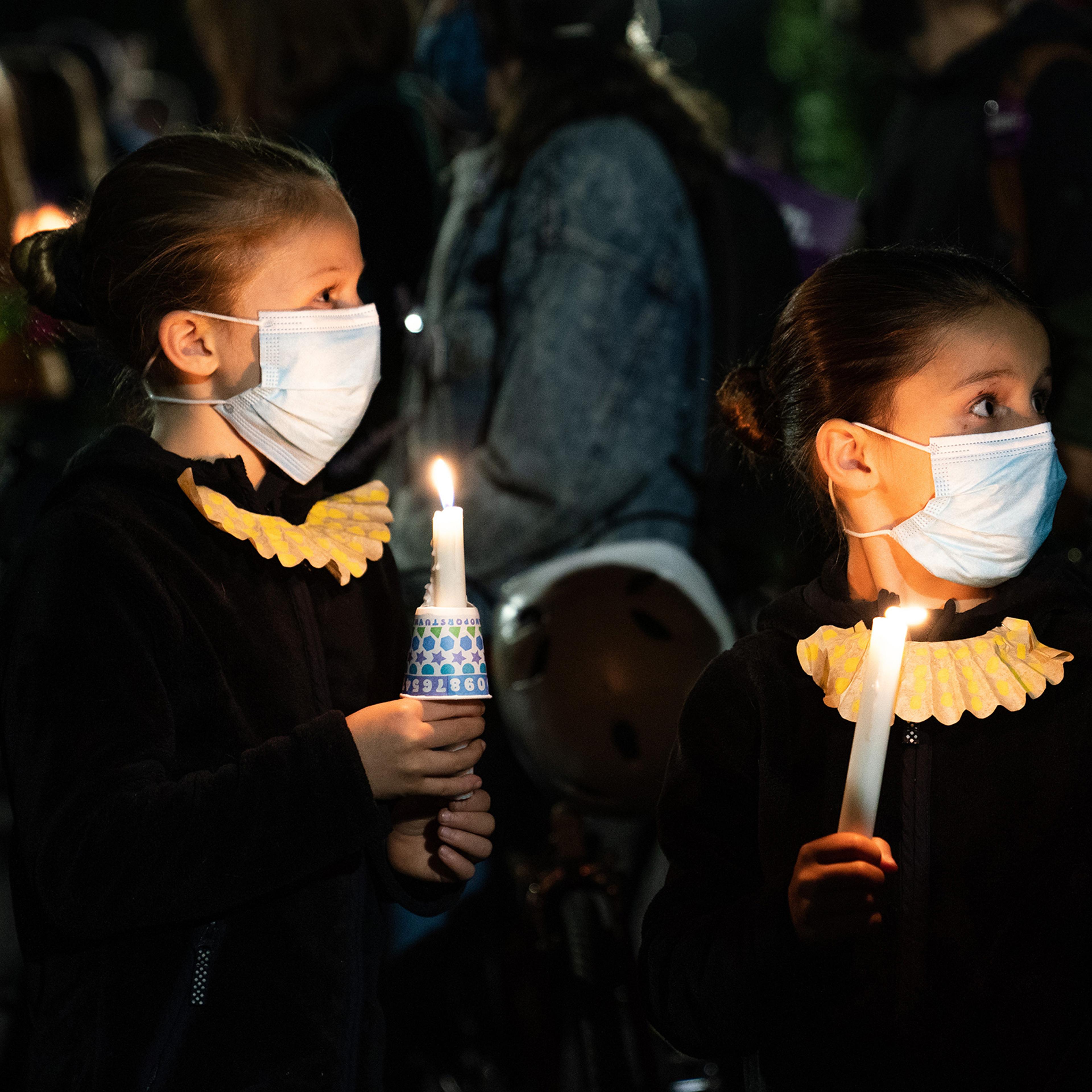 Girls dressed as Justice Ruth Bader Ginsburg stand with mourners outside the Supreme Court in Washington, D.C., on Sept. 19, a day after Ginsburg's death.