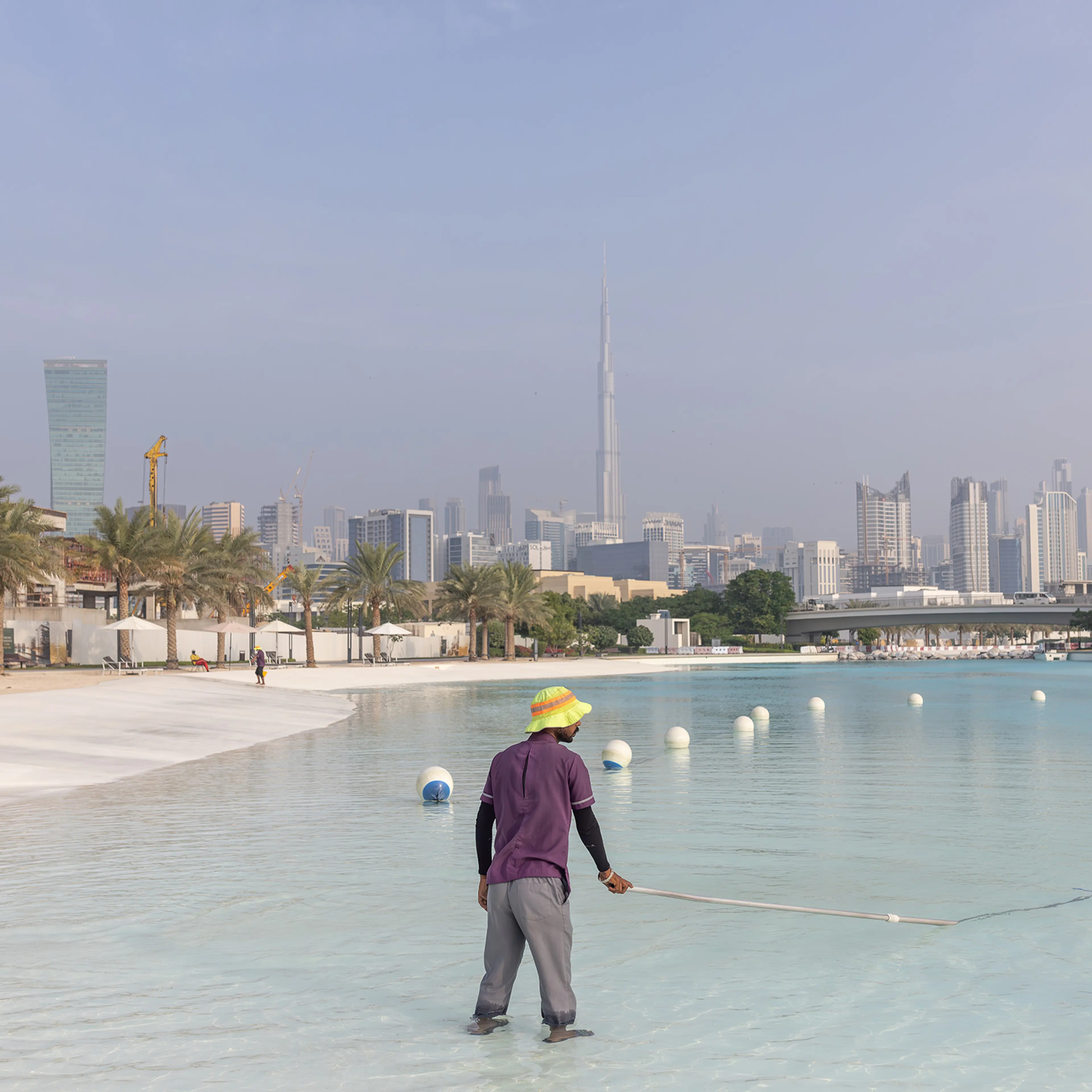 Workers clean the fresh water lagoon at District One on Nov. 21, 2023 in Dubai.