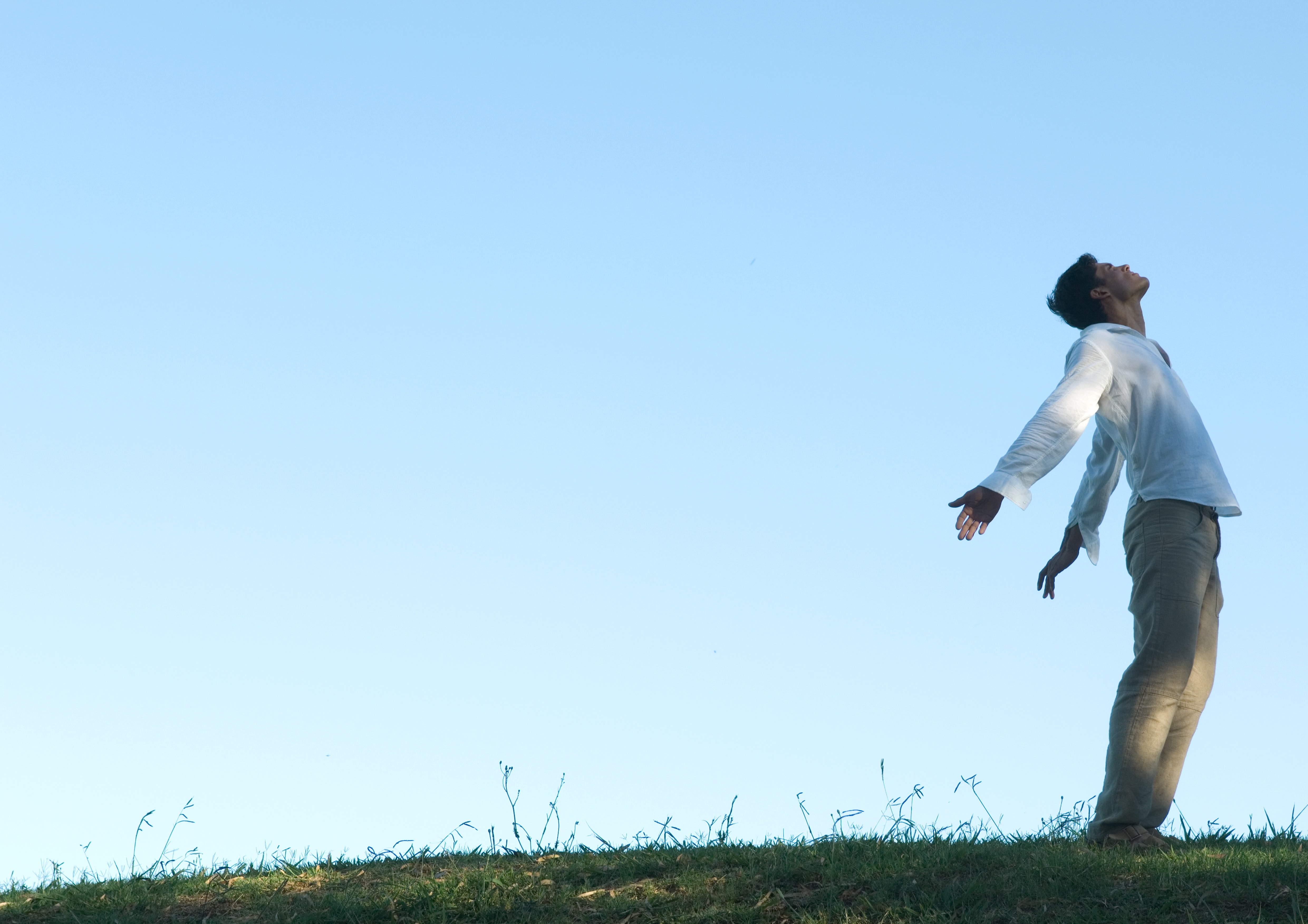Man standing outside with arms and head back
