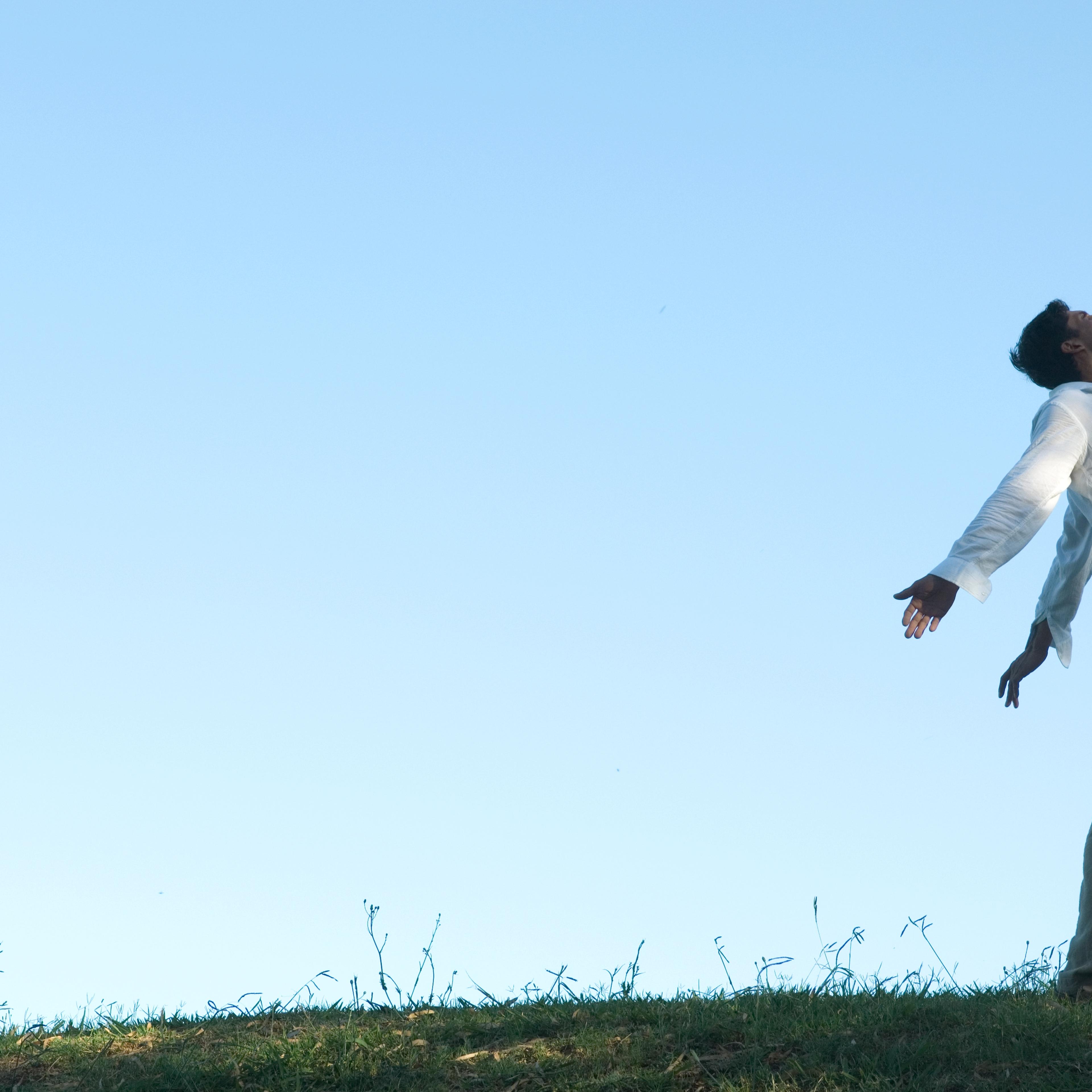 Man standing outside with arms and head back