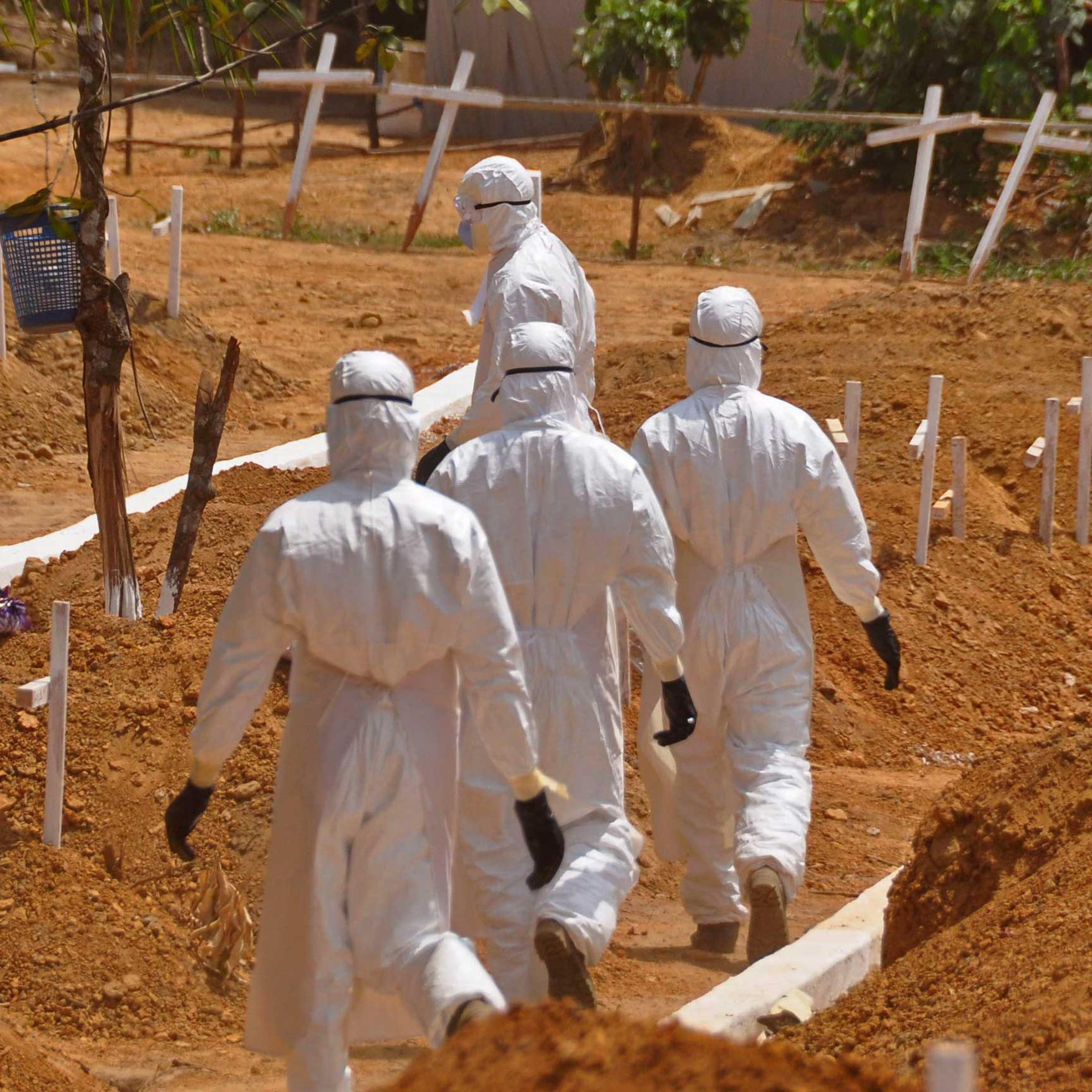 Health workers walk inside a new graveyard for Ebola victims, on the outskirts of Monrovia, Liberia on March 11, 2015.
