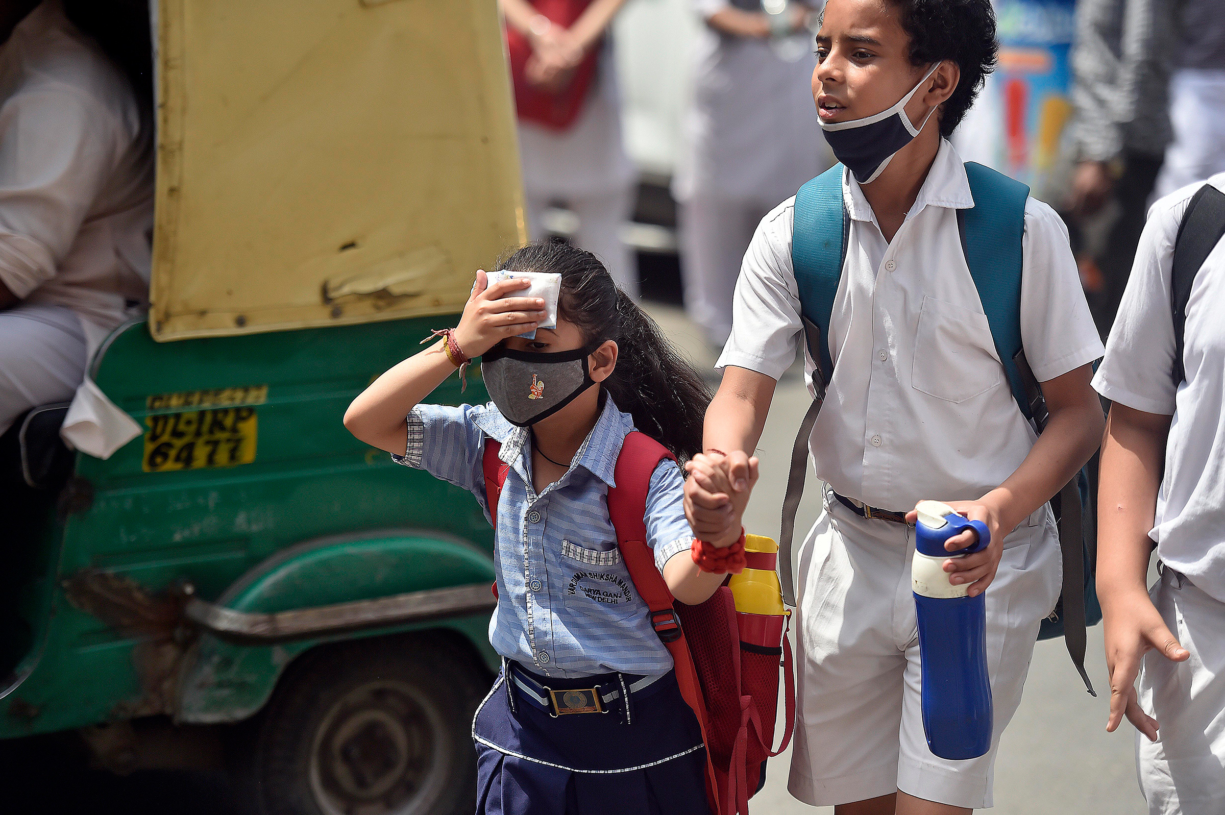 School students are seen outside a school on a hot summer day on April 26 in New Delhi.