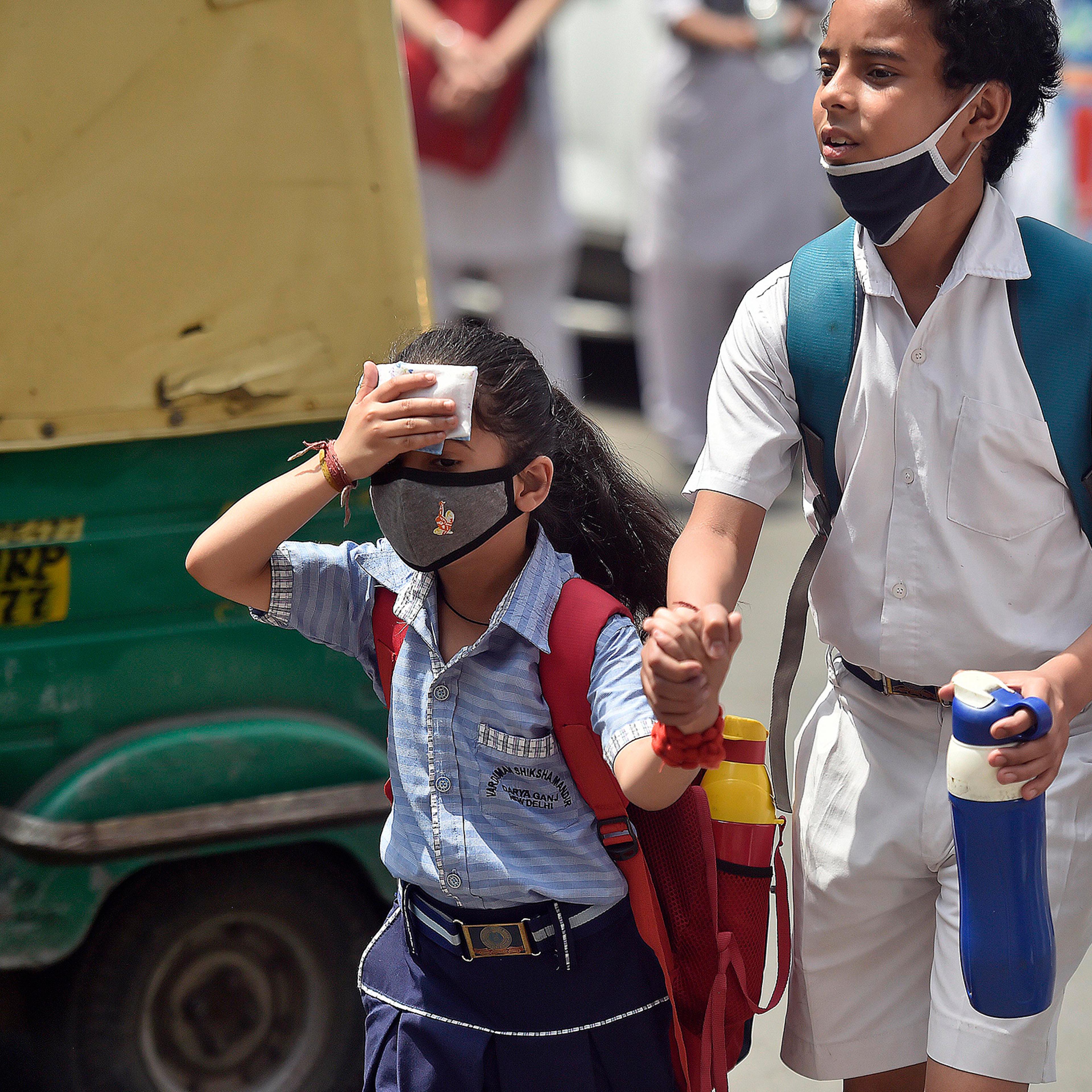 School students are seen outside a school on a hot summer day on April 26 in New Delhi.