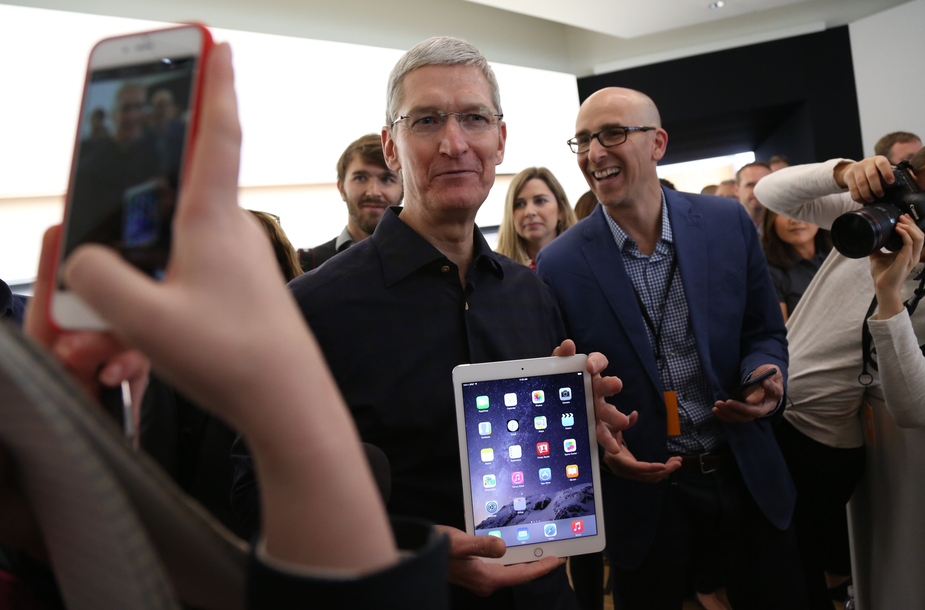 Apple CEO Tim Cook holds a new iPad after a presentation at Apple headquarters in Cupertino
