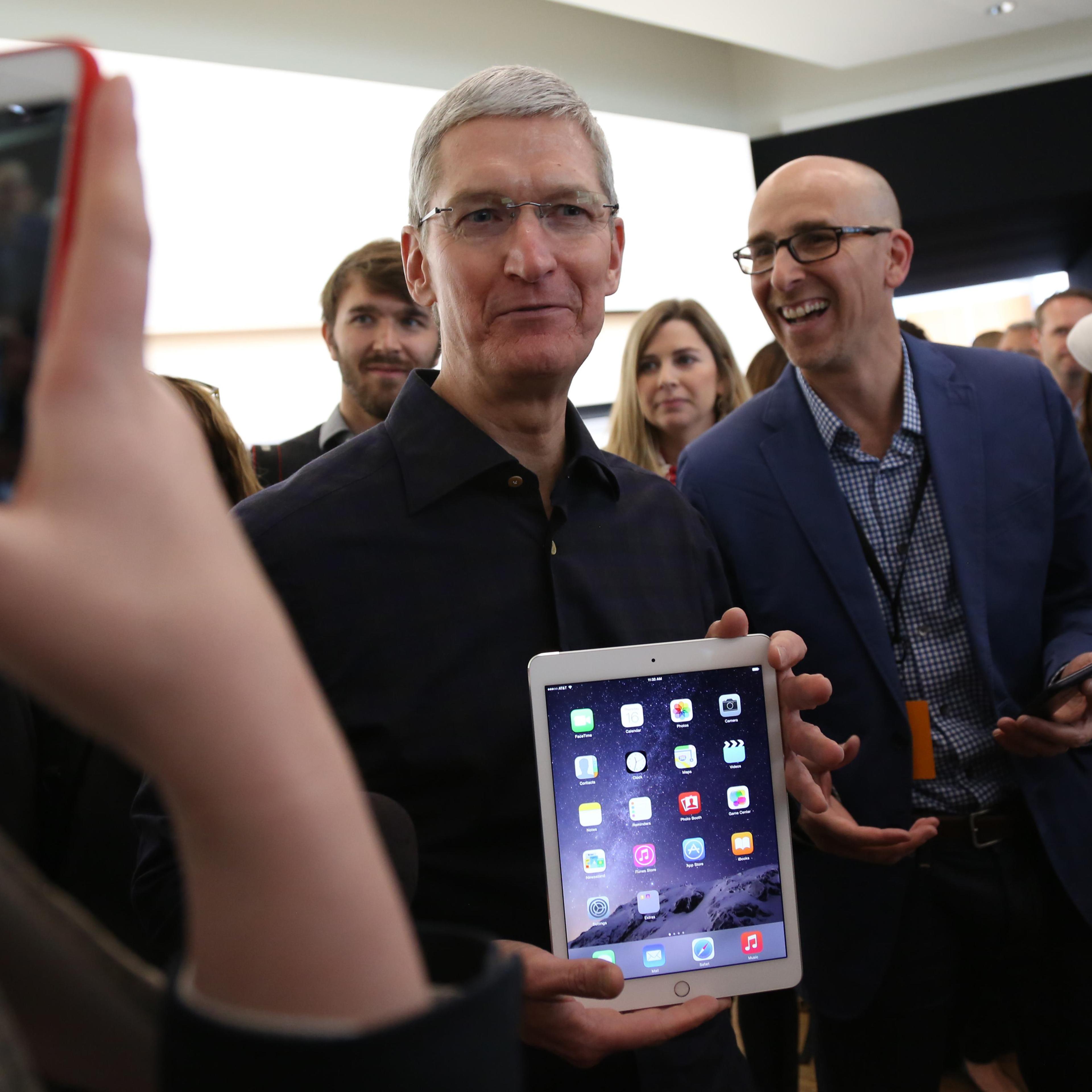 Apple CEO Tim Cook holds a new iPad after a presentation at Apple headquarters in Cupertino