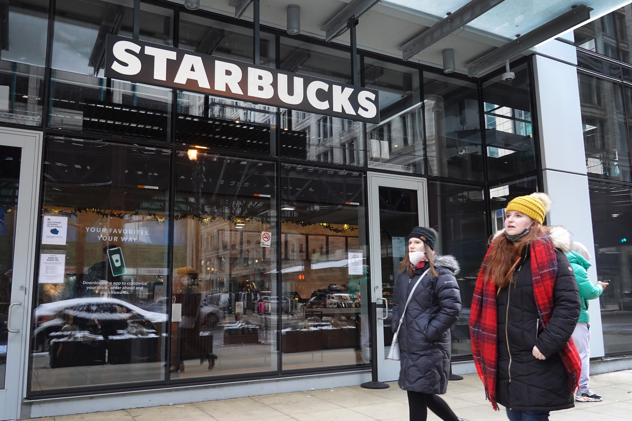 A Starbucks sign hangs above the entrance of one of the chain's coffee shops in the Loop on January 04, 2022 in Chicago, Illinois. Workers at the coffee shop have submitted signed cards seeking to join an affiliate of the Service Employees International 