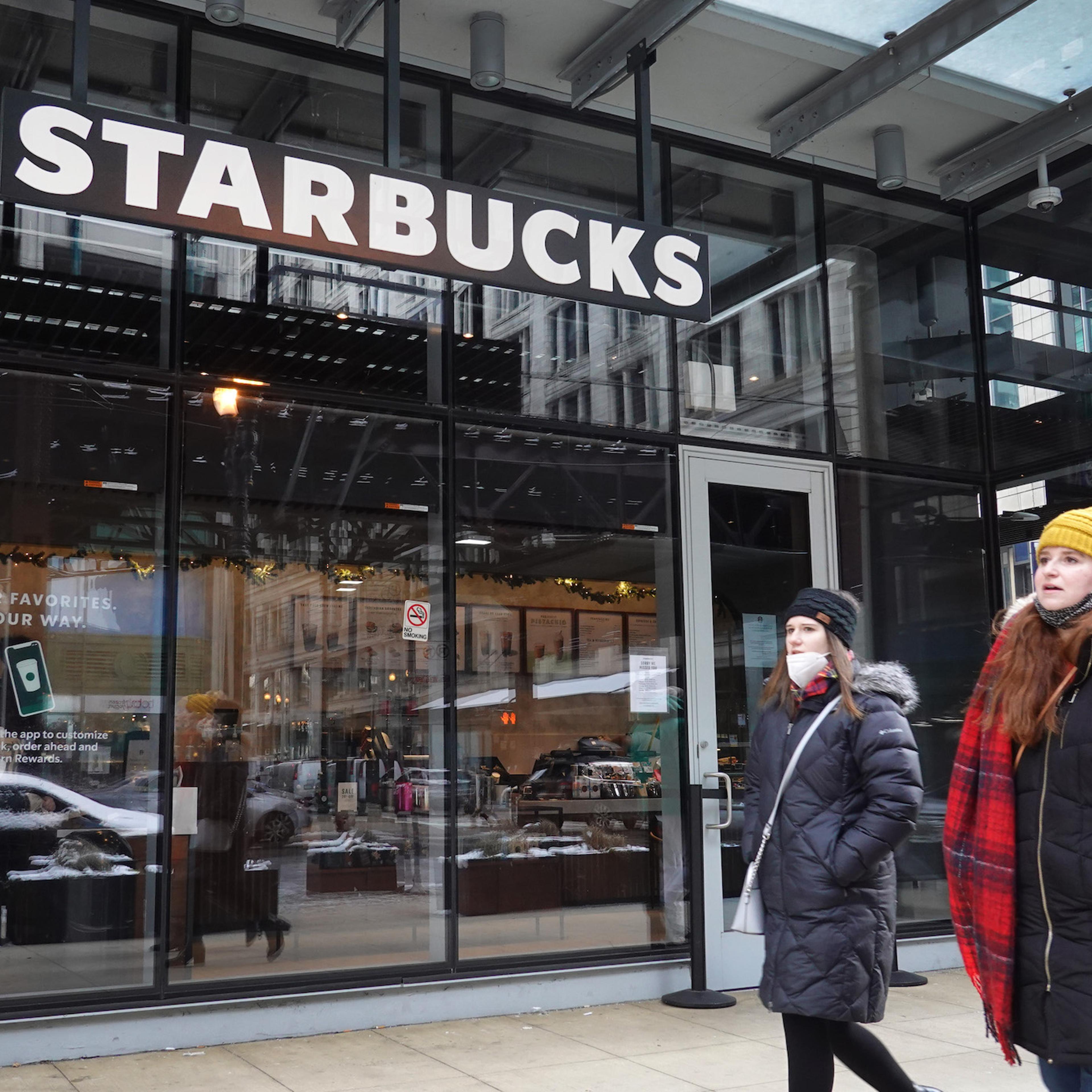 A Starbucks sign hangs above the entrance of one of the chain's coffee shops in the Loop on January 04, 2022 in Chicago, Illinois. Workers at the coffee shop have submitted signed cards seeking to join an affiliate of the Service Employees International