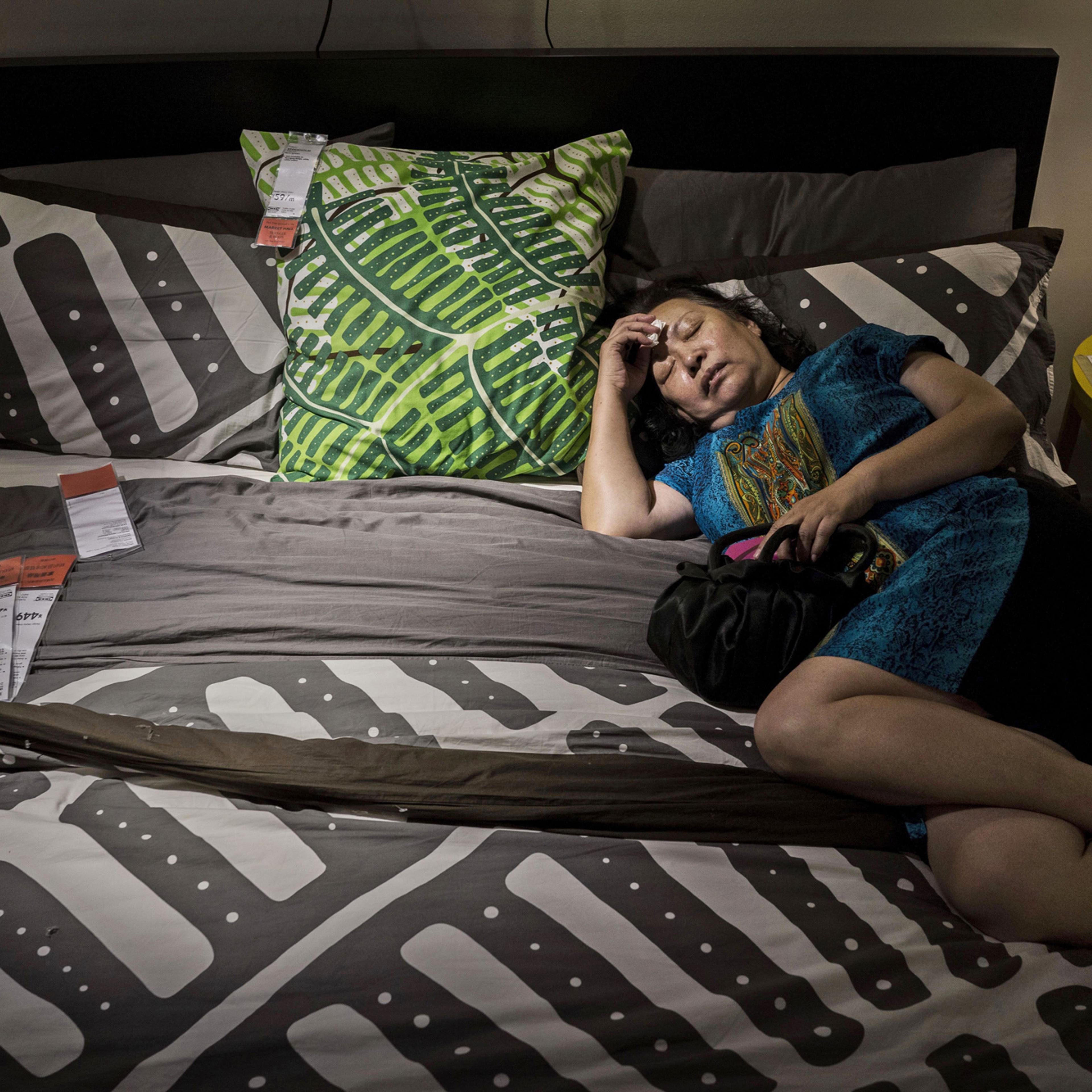 A Chinese shopper sleeps on a bed in the showroom of the IKEA store on July 6, 2014 in Beijing, China.