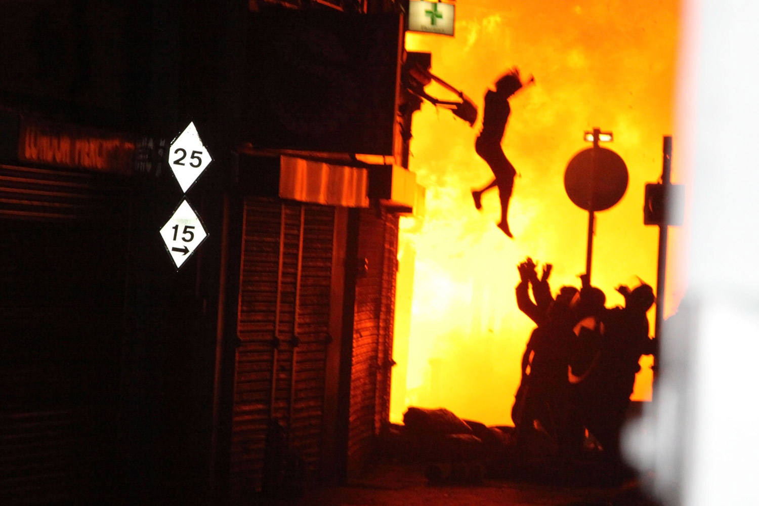 A woman is seen jumping from a burning building on Surrey Street after rioting in Croydon, England, on Aug. 8, 2011.