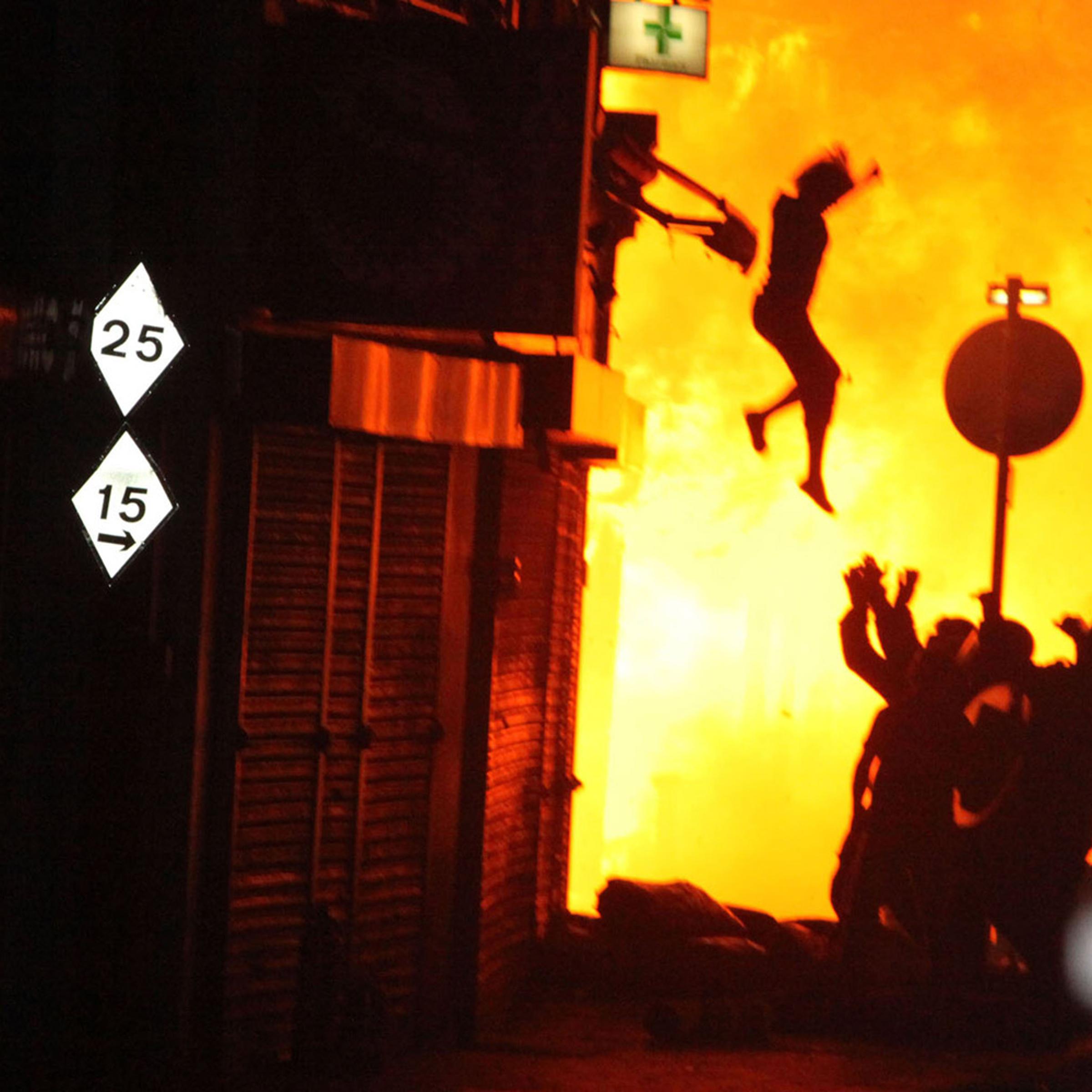 A woman is seen jumping from a burning building on Surrey Street after rioting in Croydon, England, on Aug. 8, 2011.
