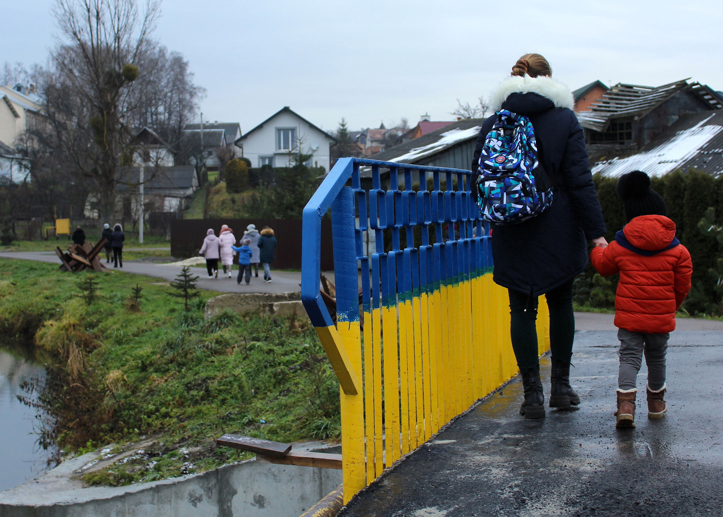 A domestic violence survivor and her child walk across a bridge during an excursion outside of Lviv, organized by the Centre for Women's Perspectives.