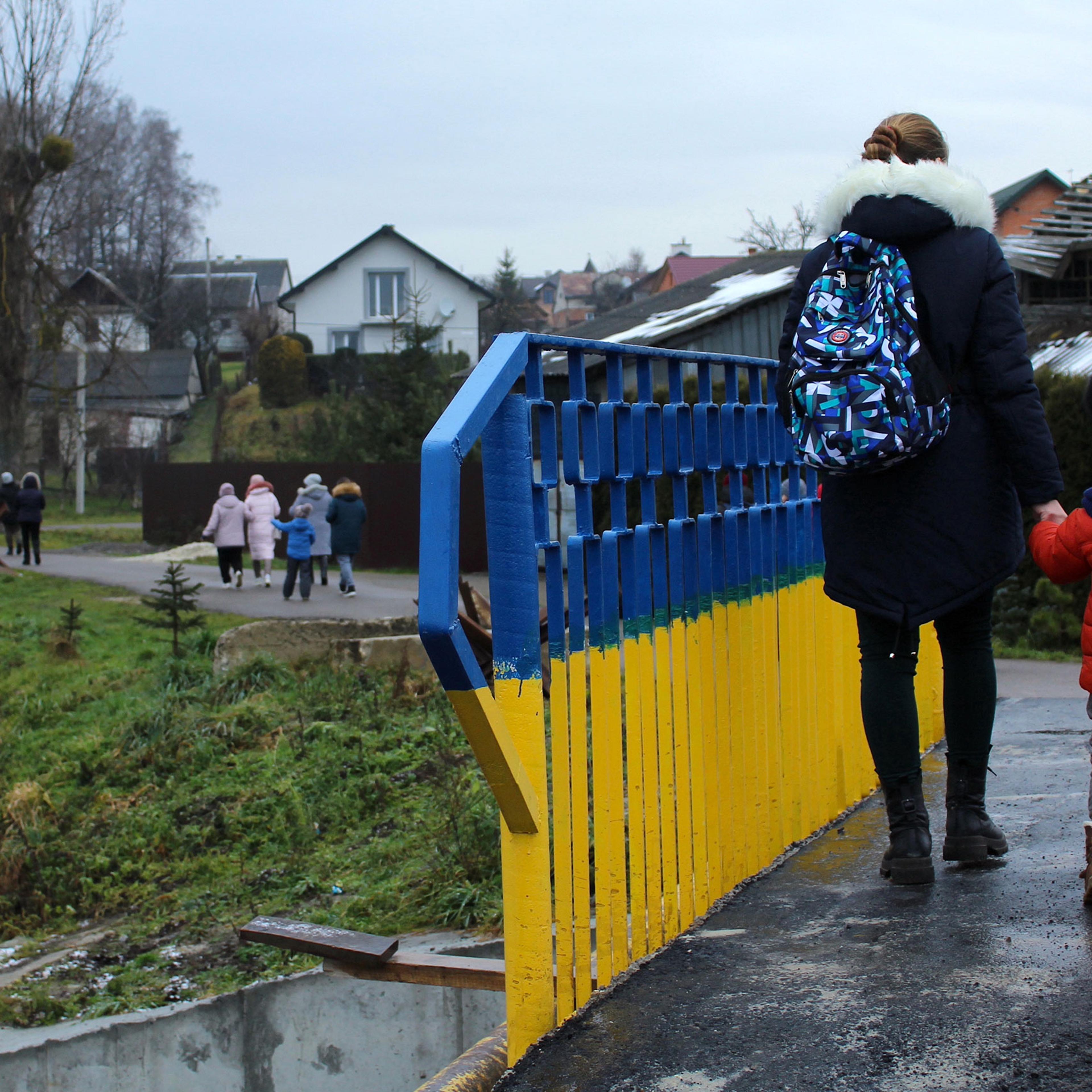 A domestic violence survivor and her child walk across a bridge during an excursion outside of Lviv, organized by the Centre for Women's Perspectives.