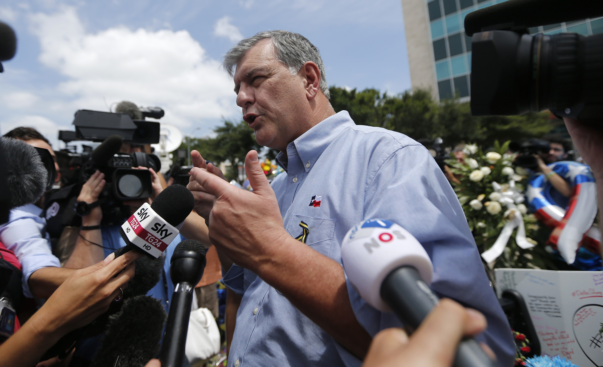 Dallas Mayor Mike Rawlings enters police headquarters after visiting a makeshift memorial of police cars, in honor of the fie slain Dallas police officers, at their headquarters in Dallas, July 9, 2016.