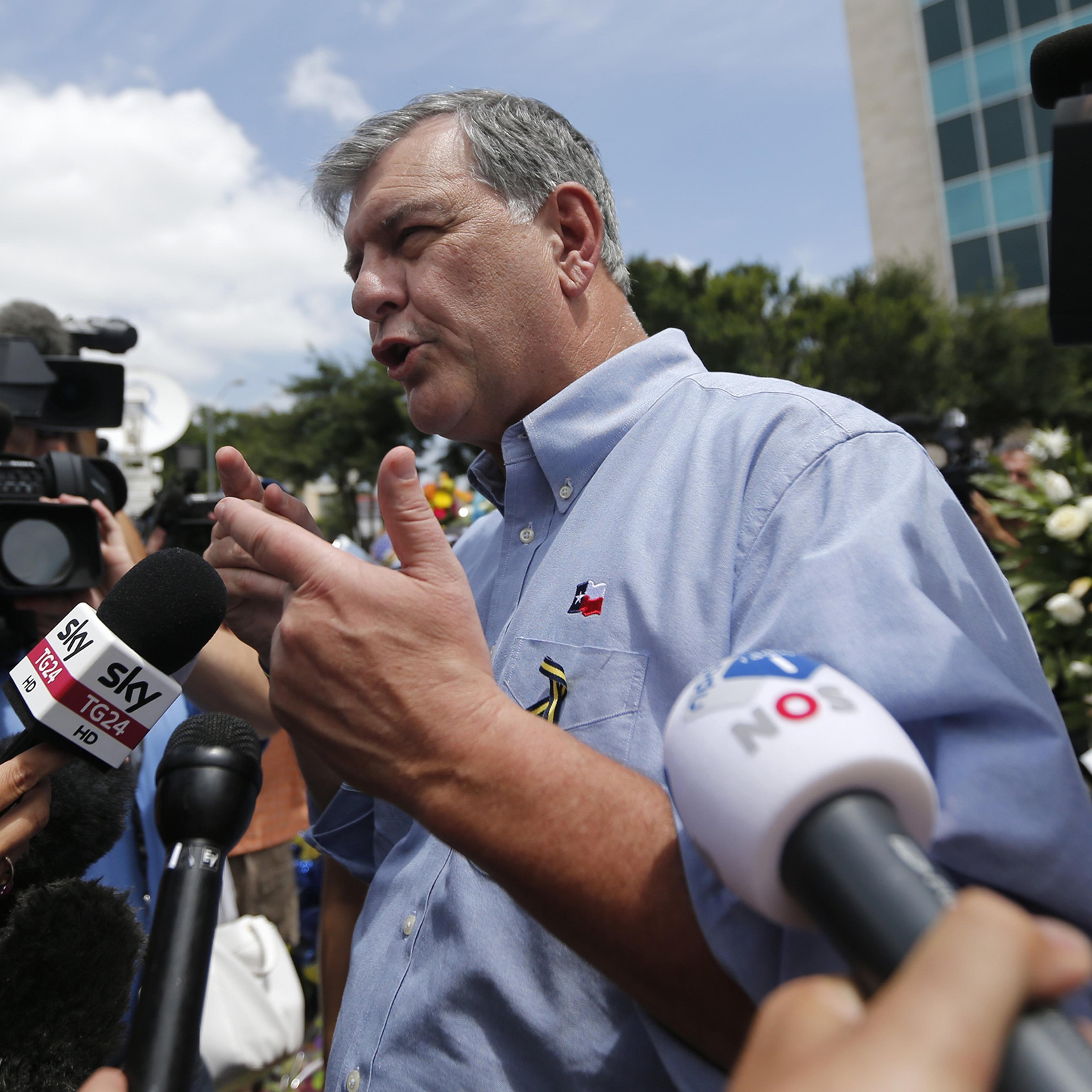 Dallas Mayor Mike Rawlings enters police headquarters after visiting a makeshift memorial of police cars, in honor of the fie slain Dallas police officers, at their headquarters in Dallas, July 9, 2016.