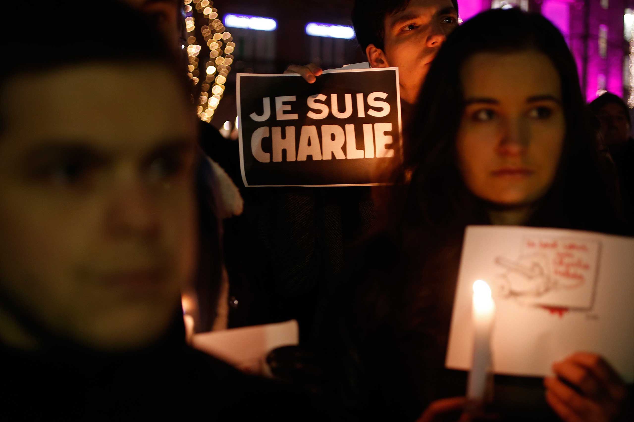 A person holds a candle in front a placard which reads "I am Charlie" to pay tribute during a gathering in Strasbourg