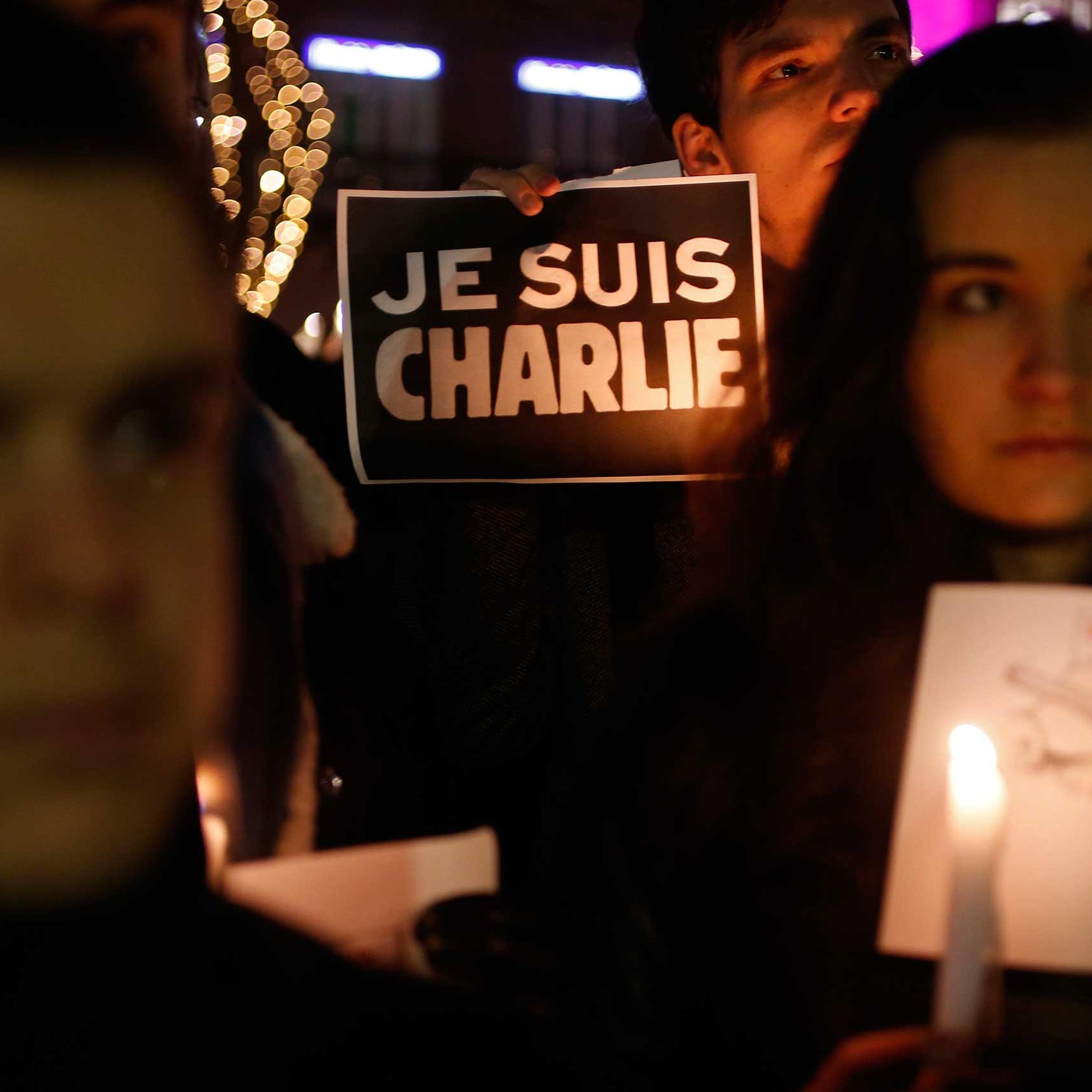 A person holds a candle in front a placard which reads "I am Charlie" to pay tribute during a gathering in Strasbourg