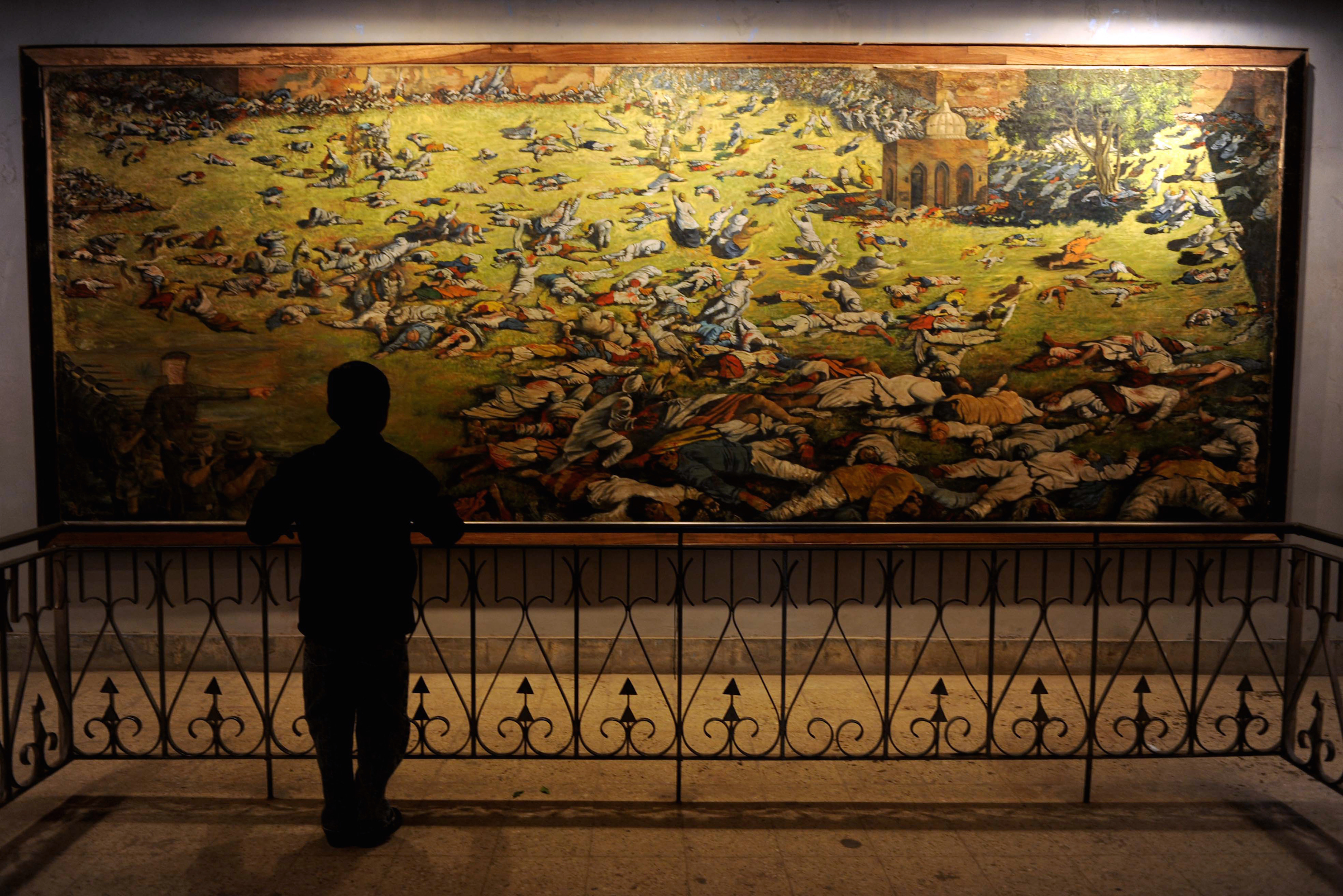 A young visitor looks at a painting depi