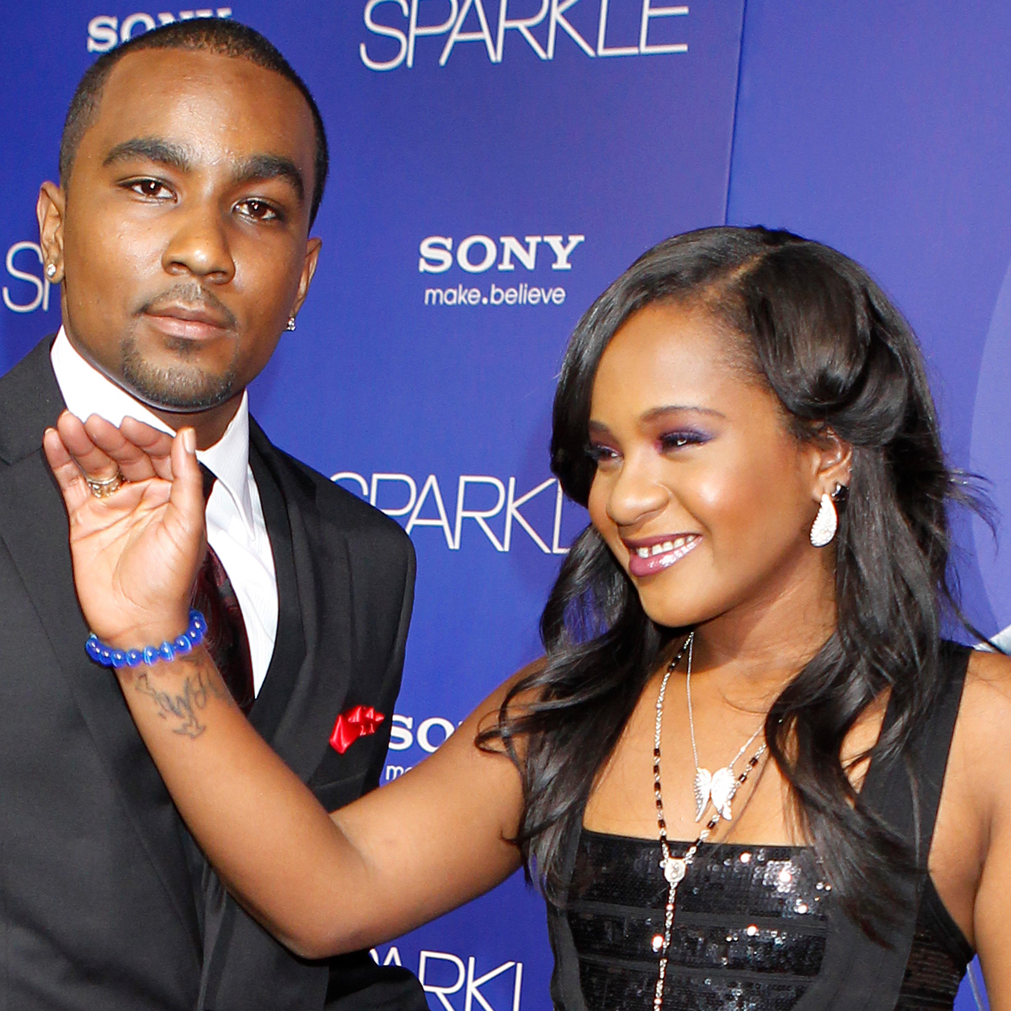 Bobbi Kristina Brown reveals a tattoo with the initials "W H" as she waves while arriving with boyfriend Nick Gordon at the premiere of the new film "Sparkle" starring Jordin Sparks and the late Whitney Houston in Hollywood