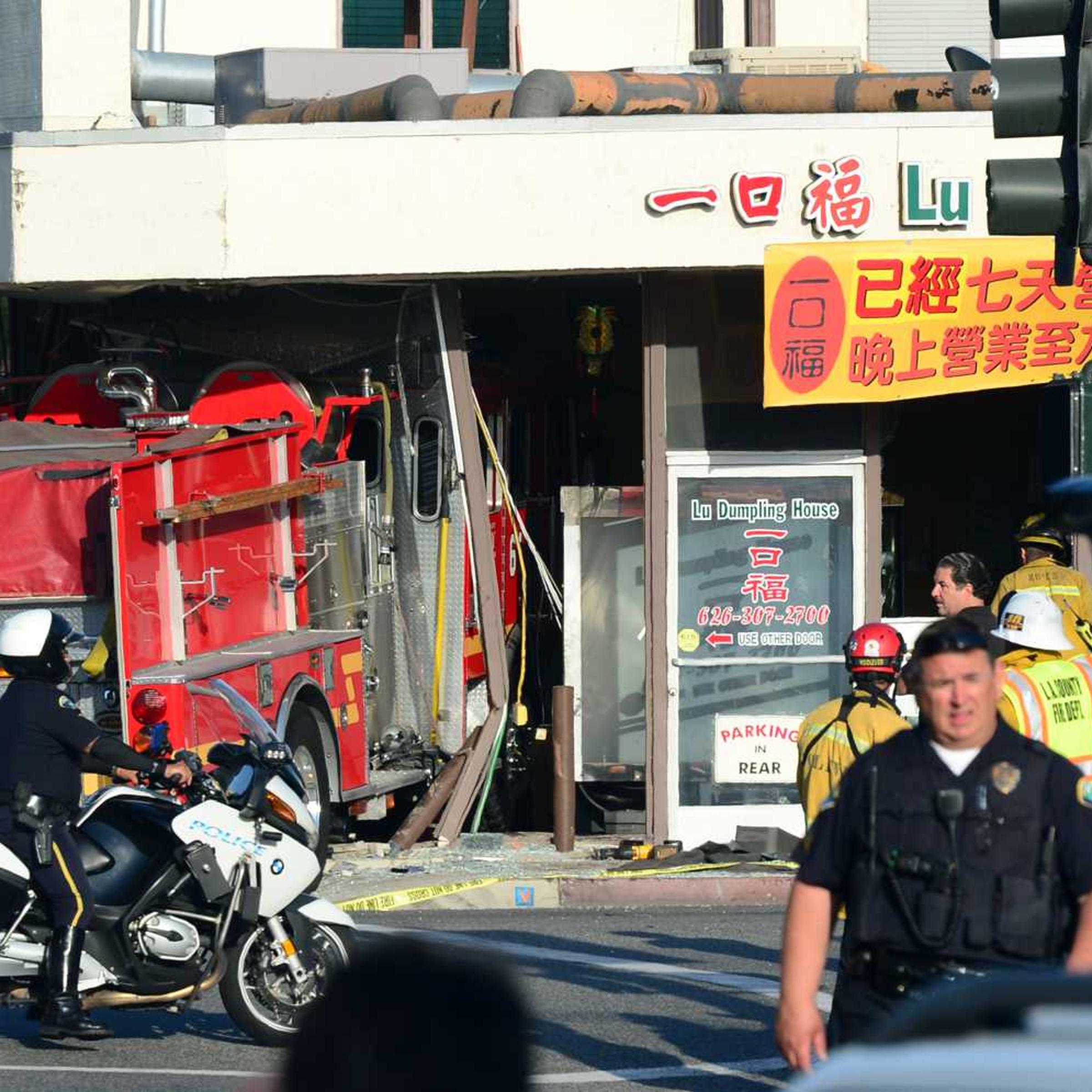 A motorcycle policeman arrives on the scene in Monterey Park, California on April 16, 2014, where two fire engines - one from the Monterey Park Fire department, another from the Alhambra Fire Department - chasing a fire crashed into each other with one barreling into a business, the Lu Dumpling House, leaving fifteen people injured.