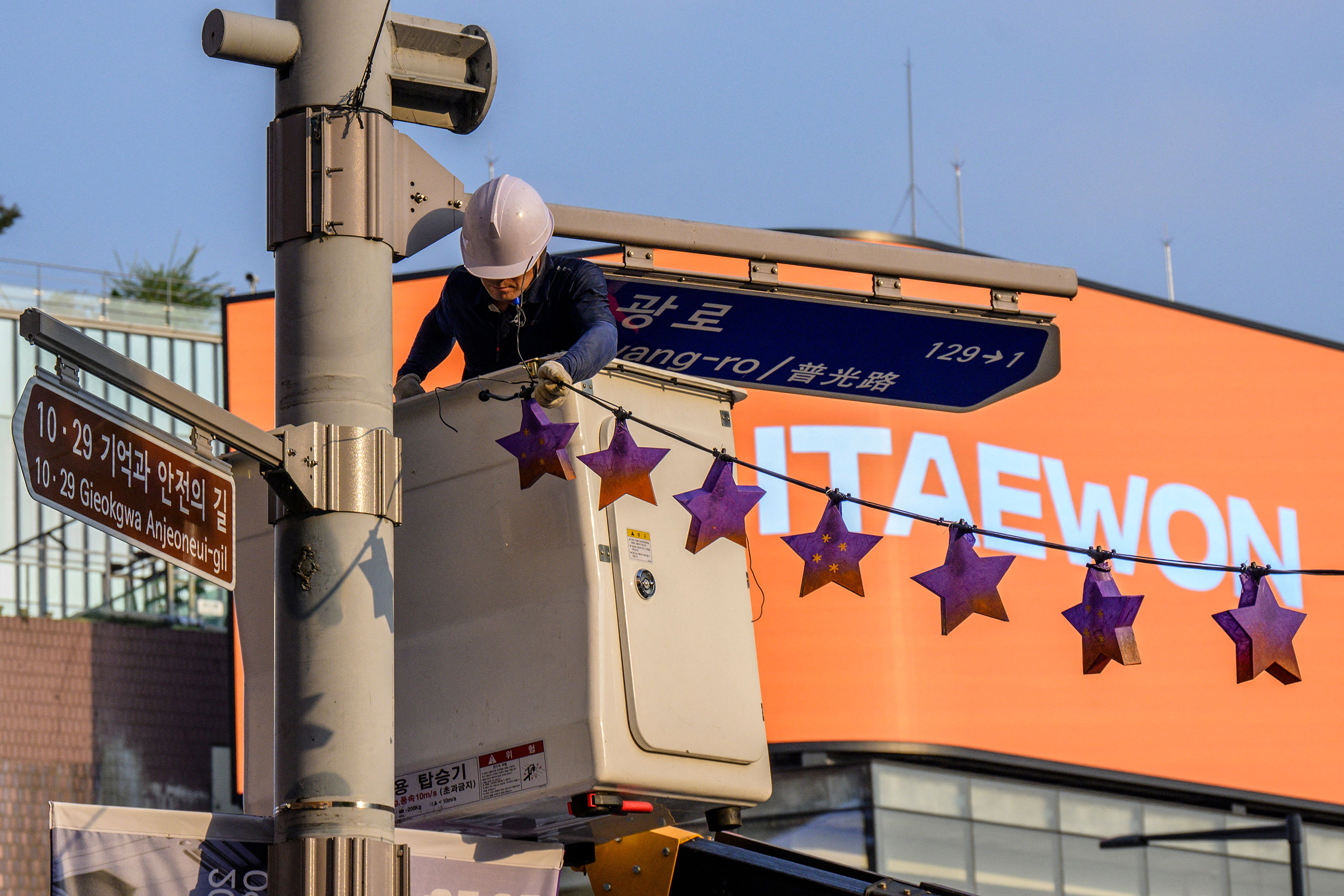 A worker displays star shaped lanterns in memory of victims of the Oct. 29 crowd crush that killed more than 150 people last Halloween, near the site of the tragedy in Itaewon, Seoul, on Oct. 25, 2023.