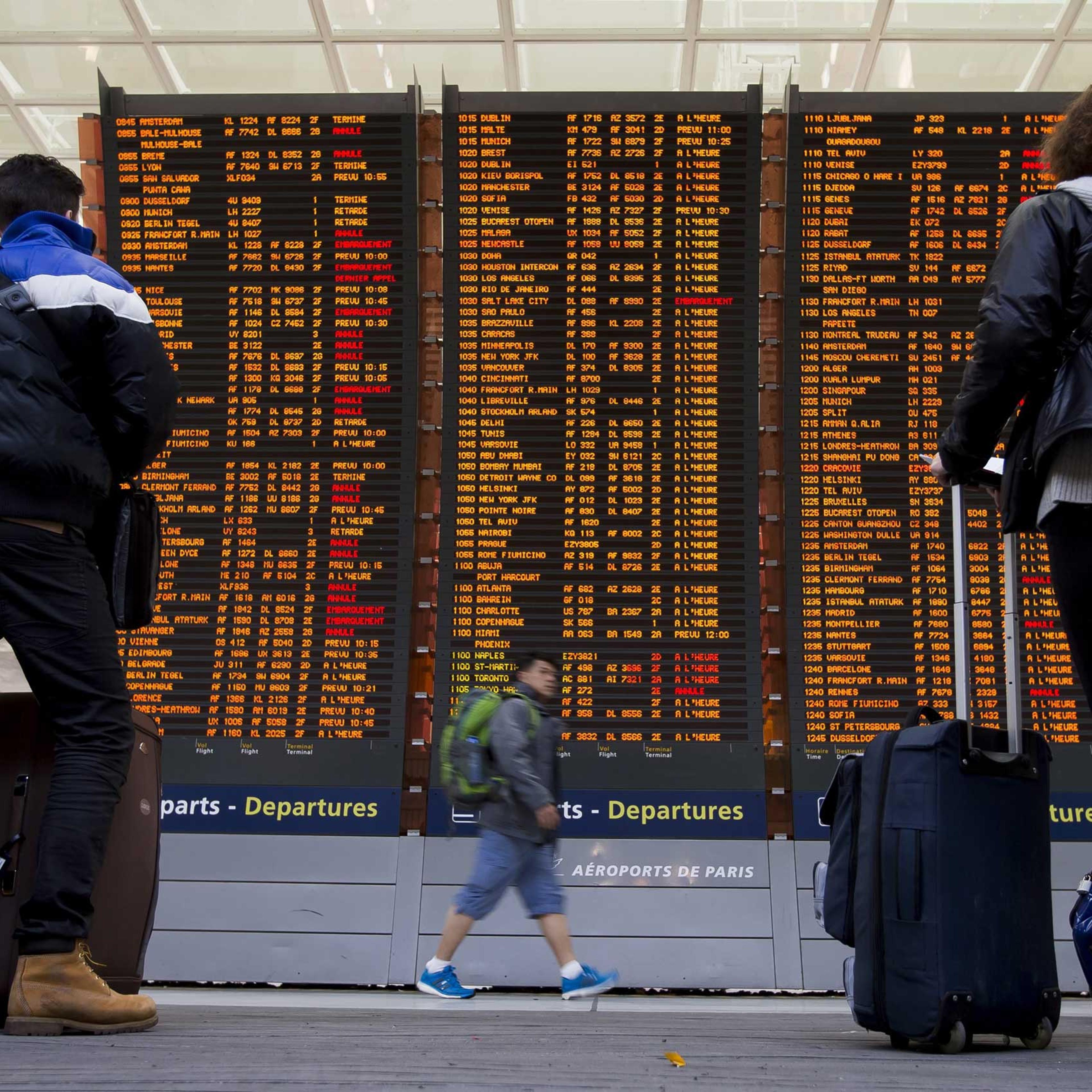 Travellers check a flight information board with various of them listed as 'cancelled' due to a strike of air traffic controllers at the Charles de Gaulle internation airport's terminal 2, in Roissy, near Paris, April 8, 2015.