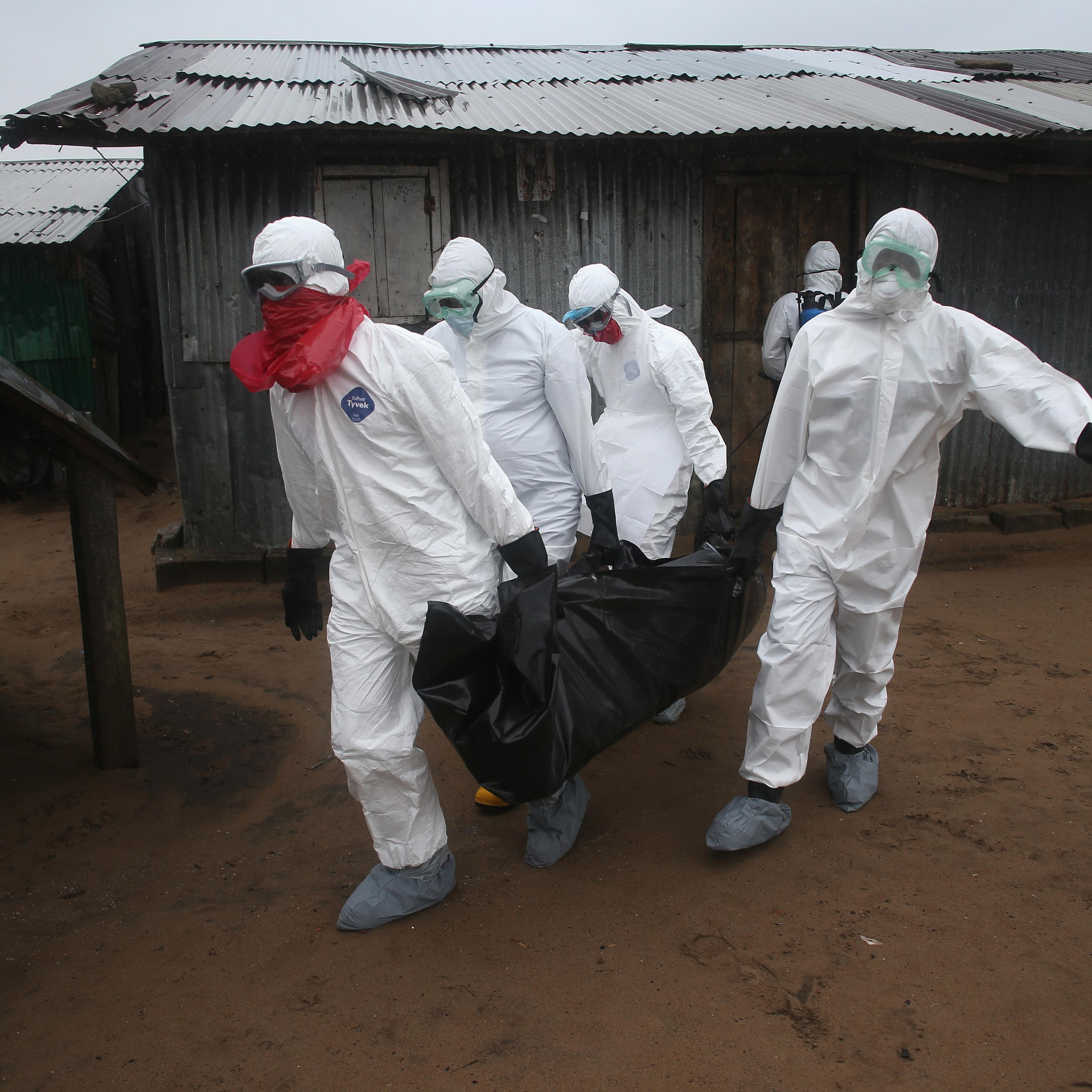 A Liberian burial team wearing protective clothing retrieves the body of a 60-year-old Ebola victim from his home on August 17, 2014 near Monrovia, Liberia.