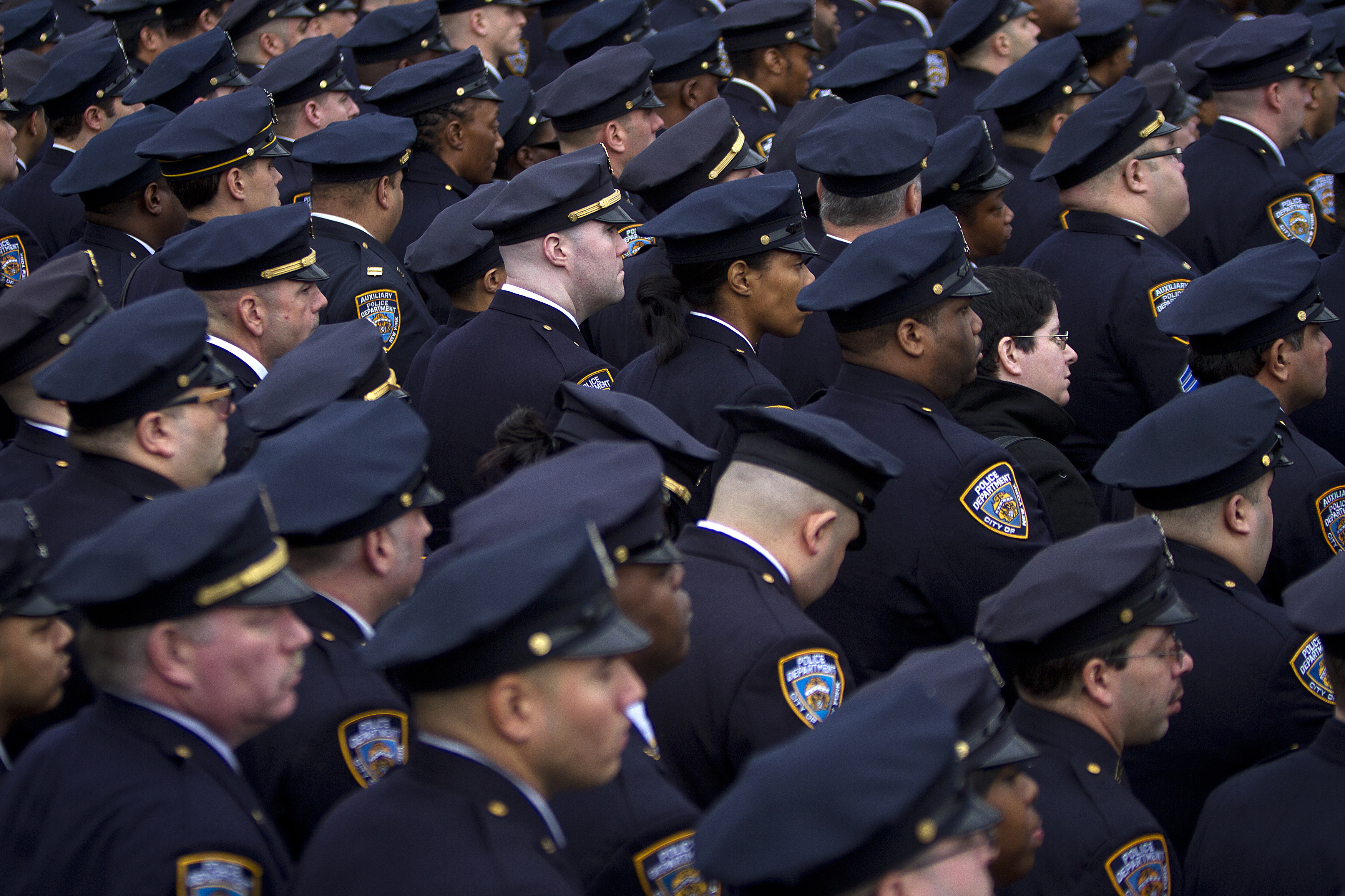 Police officers from the 84th Precinct listen during the funeral for slain New York Police Department officer Liu in the Brooklyn borough of New York