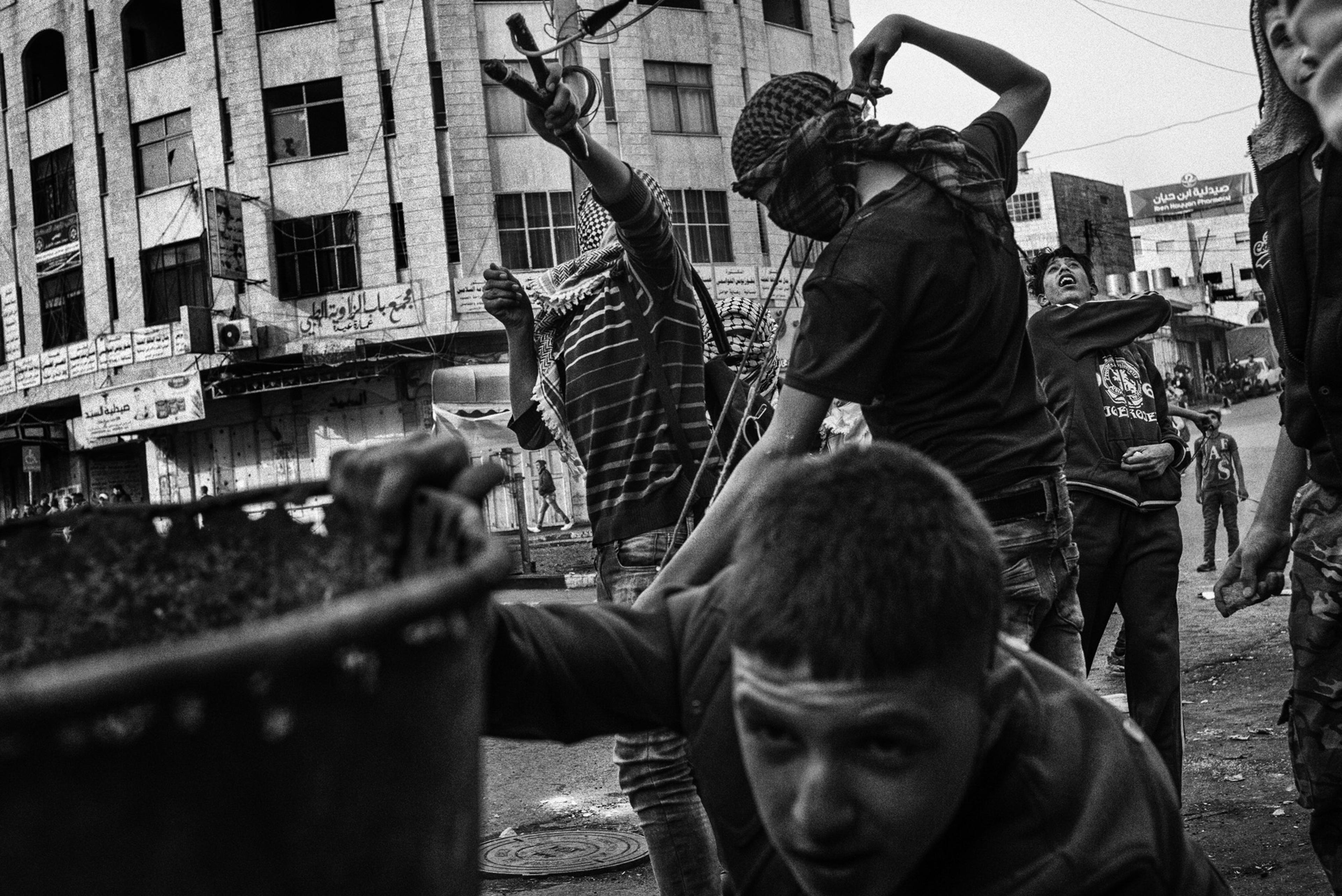 Palestinian stone-throwers gather near a main checkpoint in Hebron, November 2015.