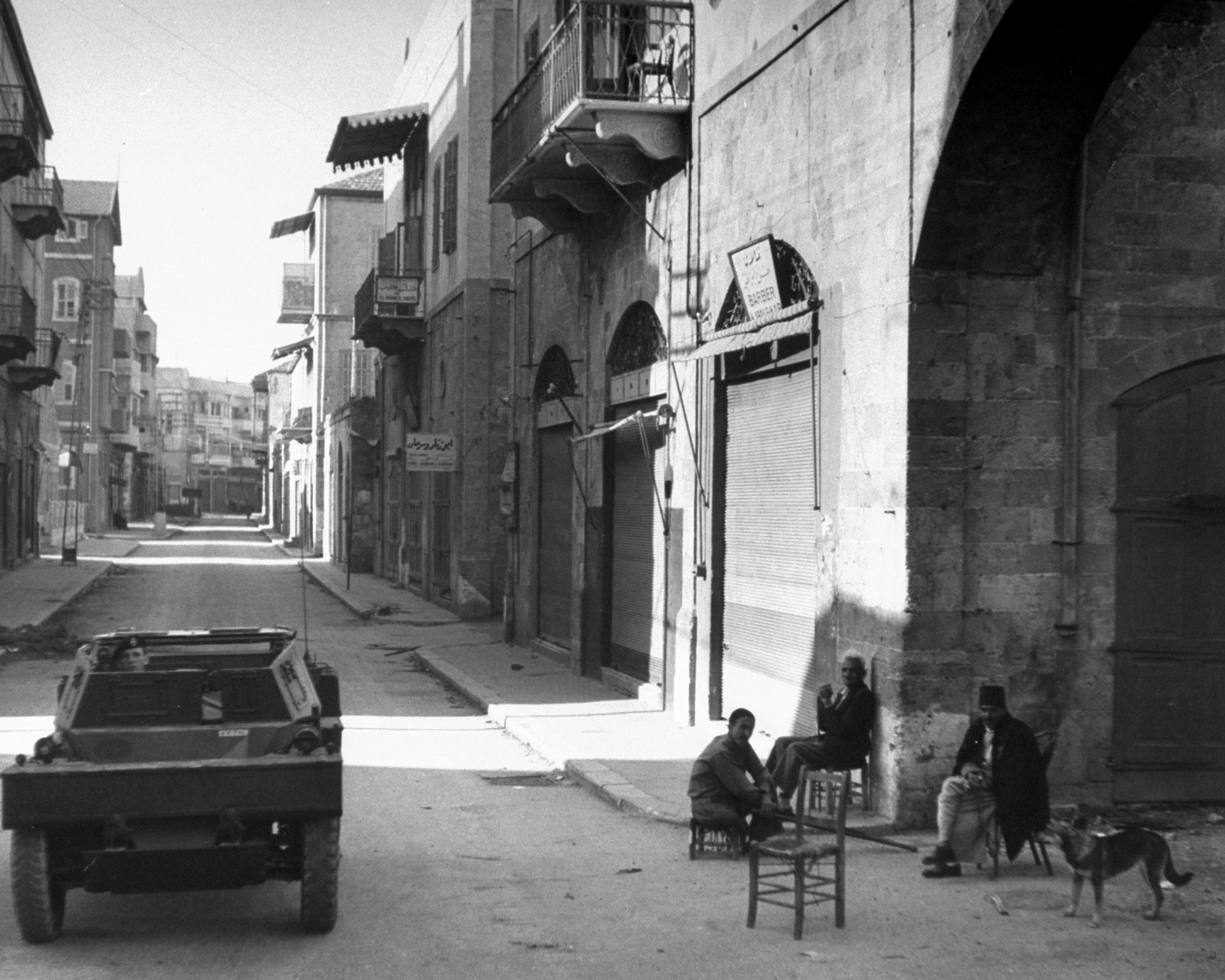 Men watch as an Israeli military vehicle passes by, shortly after the establishment of the state of Israel, exact location unknown, May 1948.