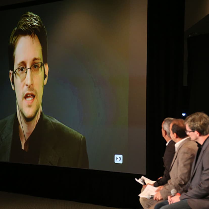 Edward Snowden on monitor speaks to panelist (L-R) Andy Bichlbaum, Mike Bonanno and actor David Neal during Politicon at the Los Angeles Convention Center on October 10, 2015 in Los Angeles, California.