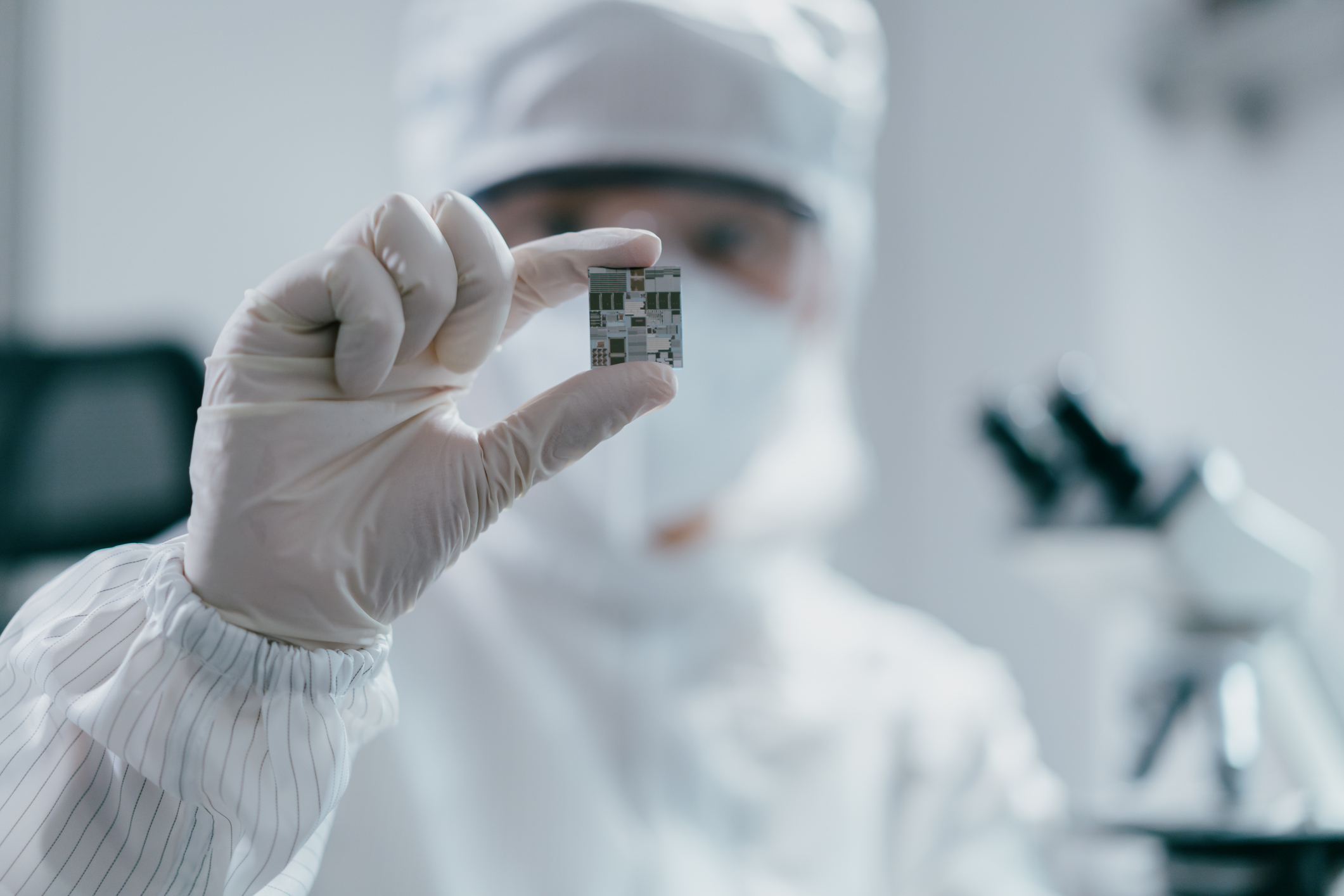 Female engineer inspecting wafer chip in laboratory
