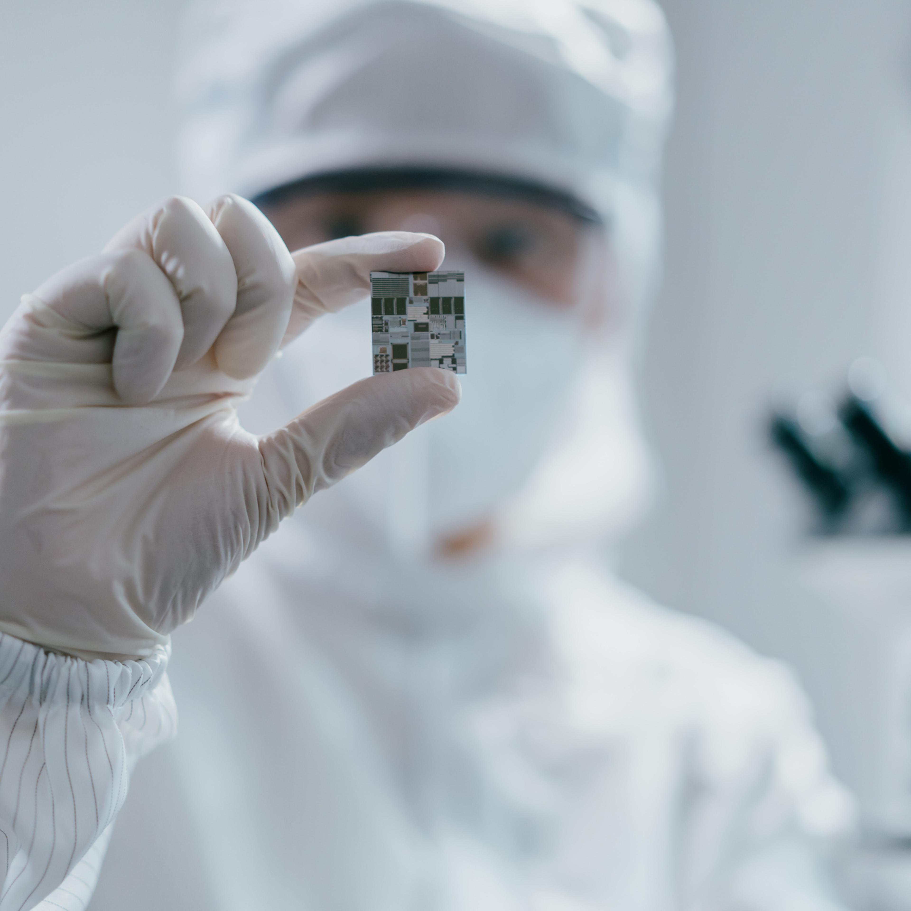 Female engineer inspecting wafer chip in laboratory