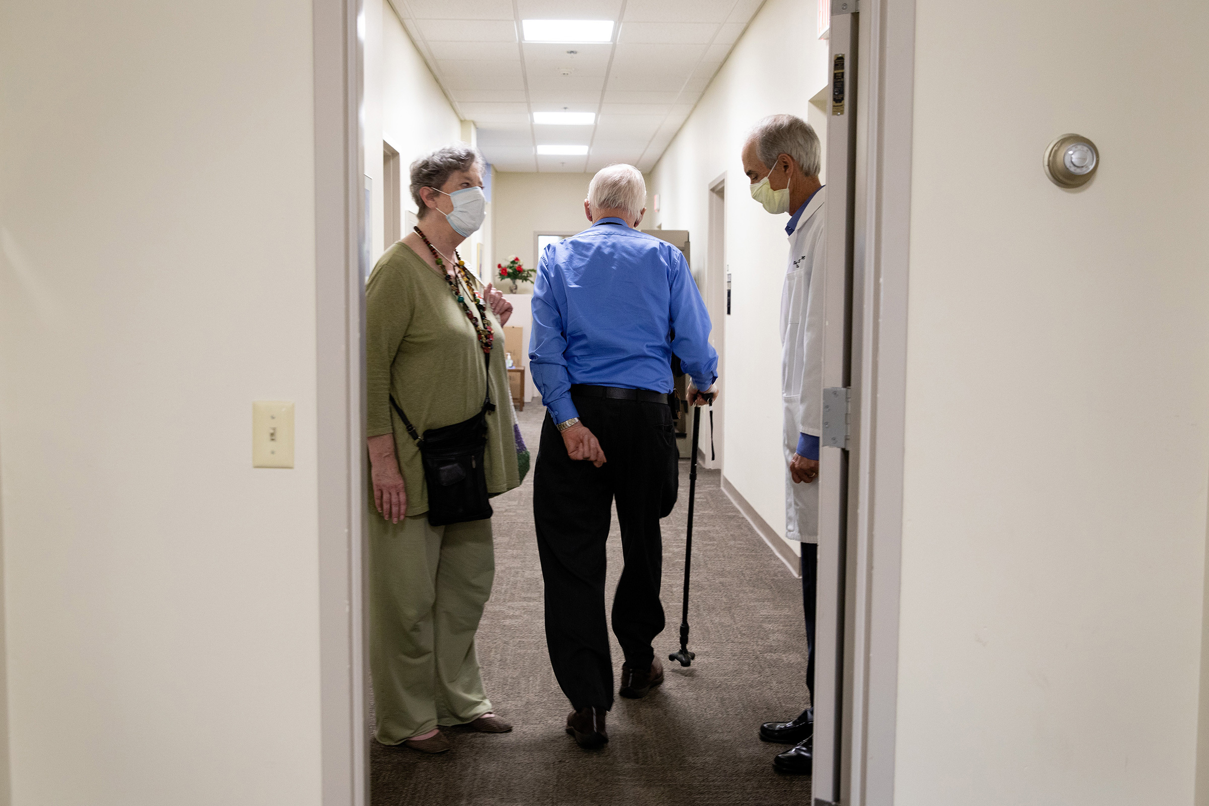 Henry Magendantz, center, a participant in the clinical trial of the experimental Alzheimer's drug, aducanumab, with his wife, Kathy Jellison, and Dr. Stephen Salloway, leaving the hospital after receiving an infusion in Providence, R.I., on May 27, 2021