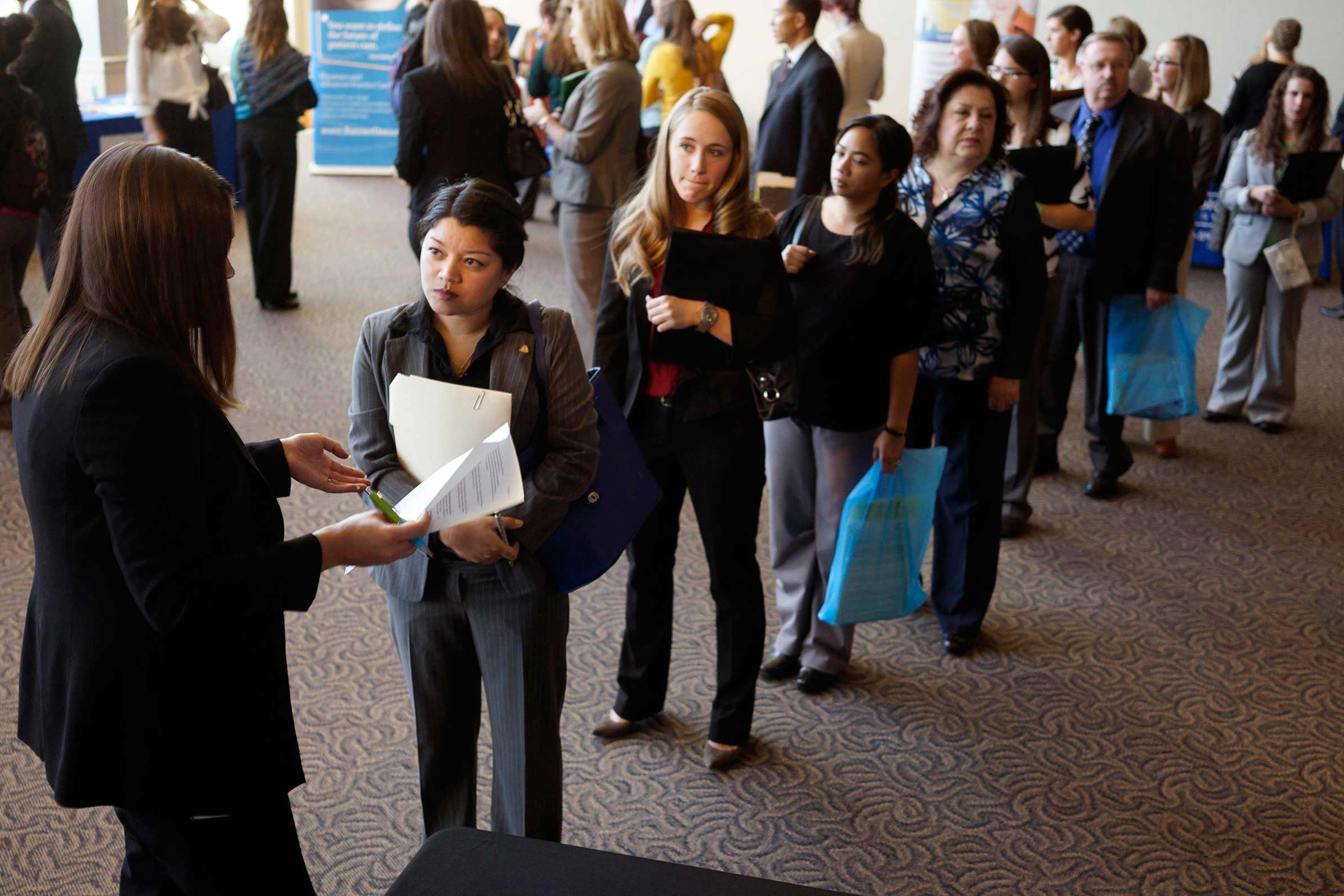 Jobseekers wait to talk to a recruiter at the Colorado Hospital Association's health care career event in Denver, Oct. 13, 2014.