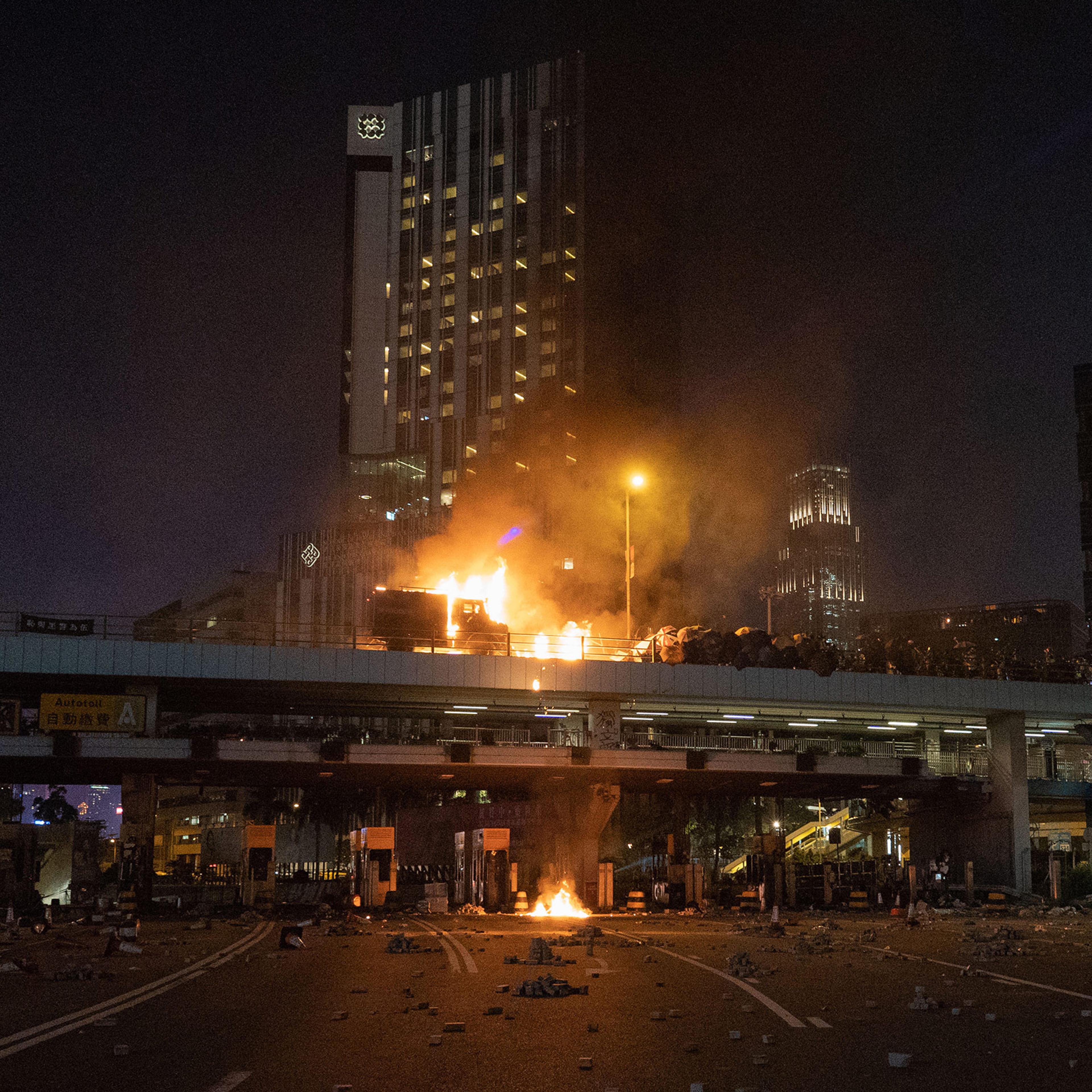 An armored police van is engulfed in flames on a bridge overlooking the Cross-Harbour Tunnel, Nov. 17, 2019.